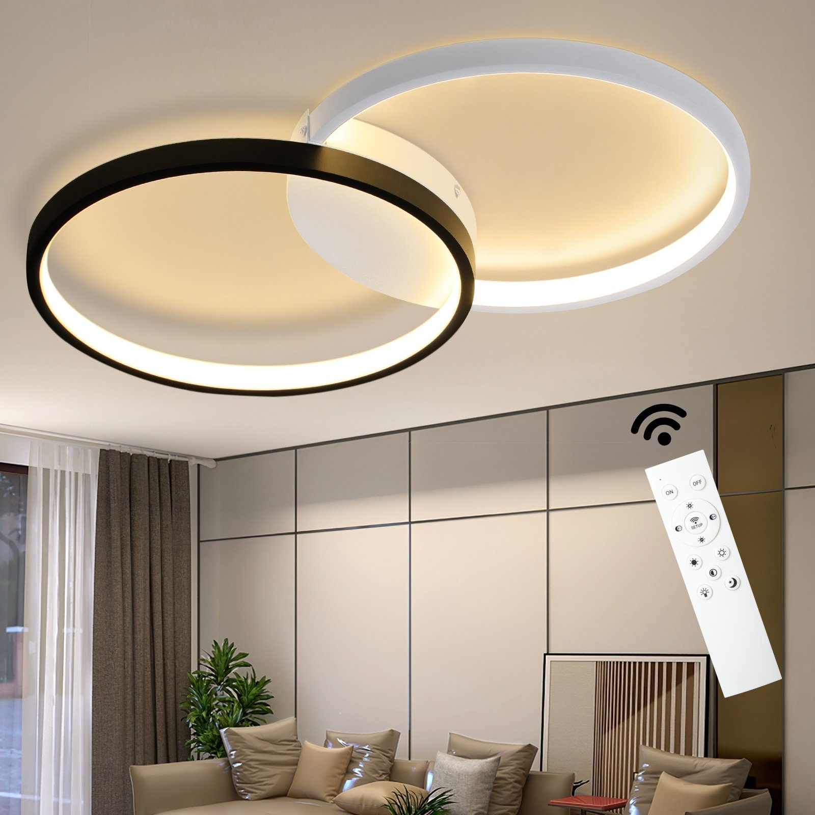 Eine moderne Deckenlampe mit zwei sich überlappenden Ringen, einer schwarz, einer weiß, in einem Wohnzimmer.