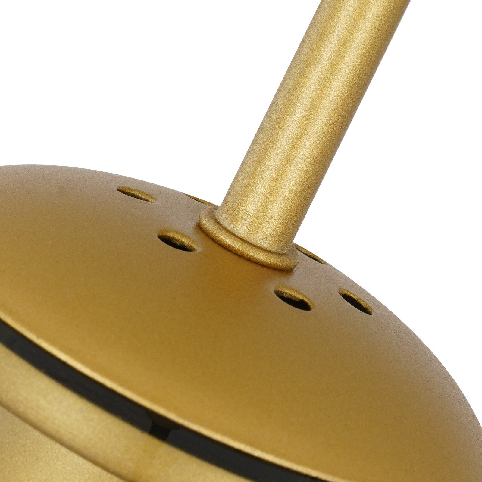 Zbliżenie złotego elementu lampy. Lampa ma okrągłą podstawę z otworami i cylindryczne ramię.