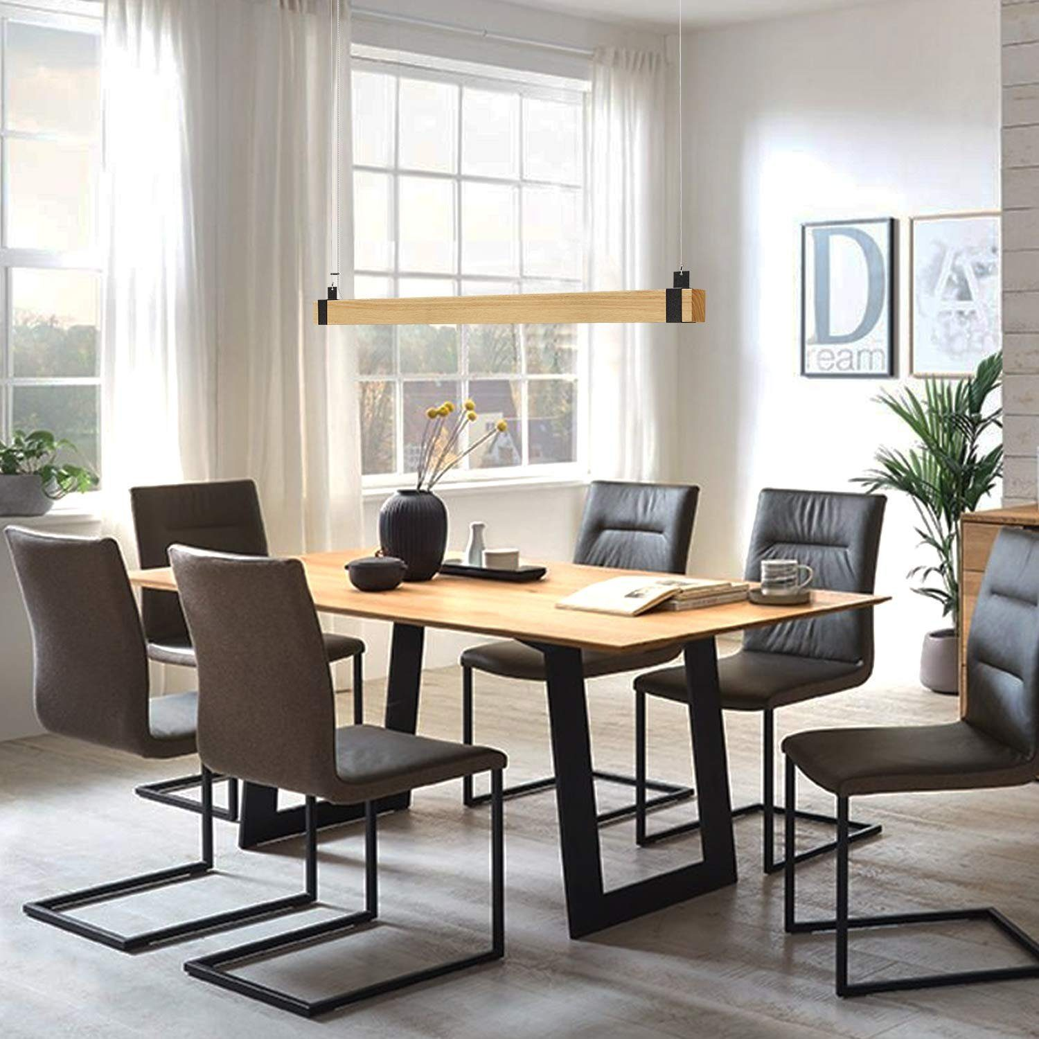 Esszimmer mit Holztisch, Stühlen und rechteckiger Leuchte über dem Tisch.