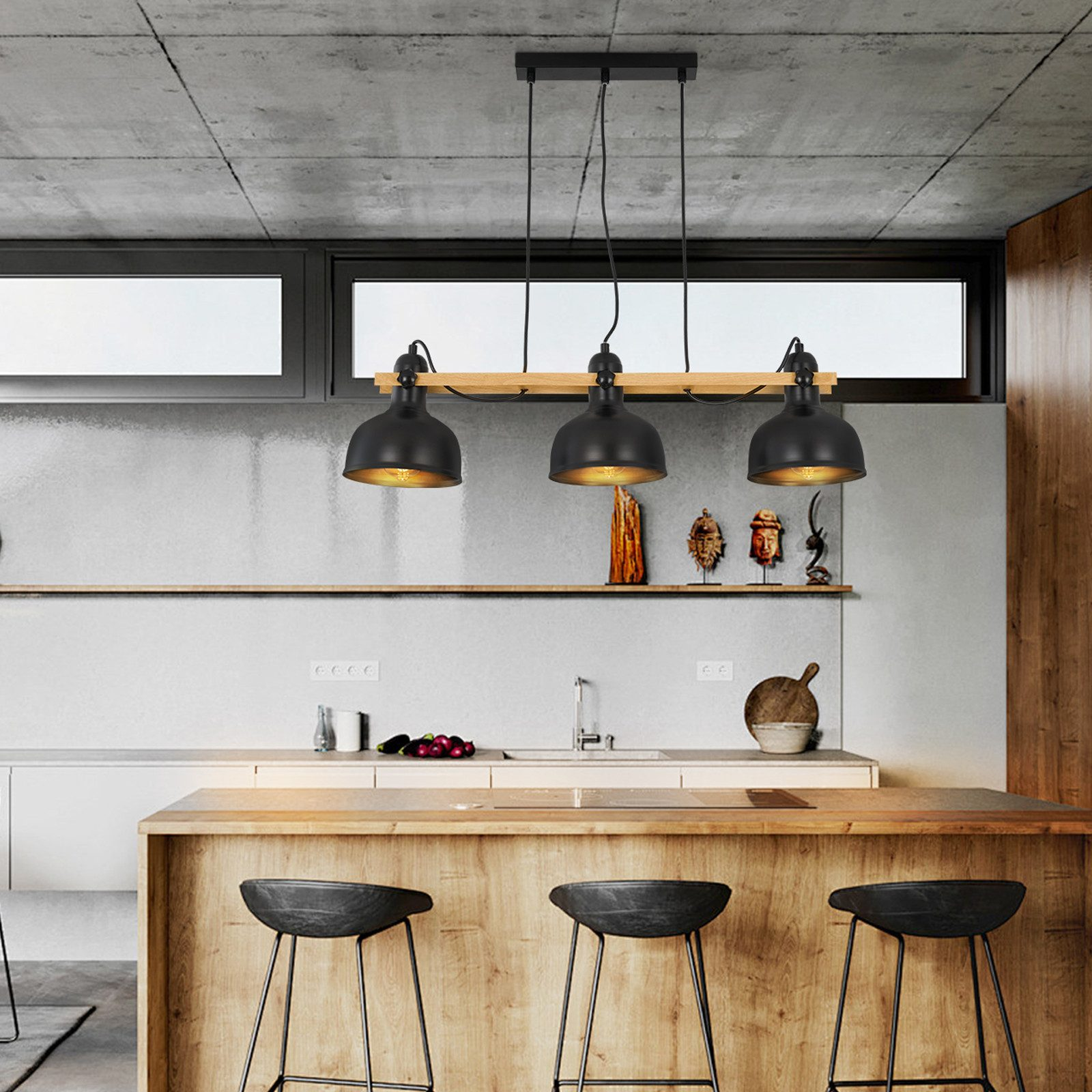 Kuchnia z trzema czarnymi lampami wiszącymi z drewnianą belką, nad drewnianym blatem ze stołkami.