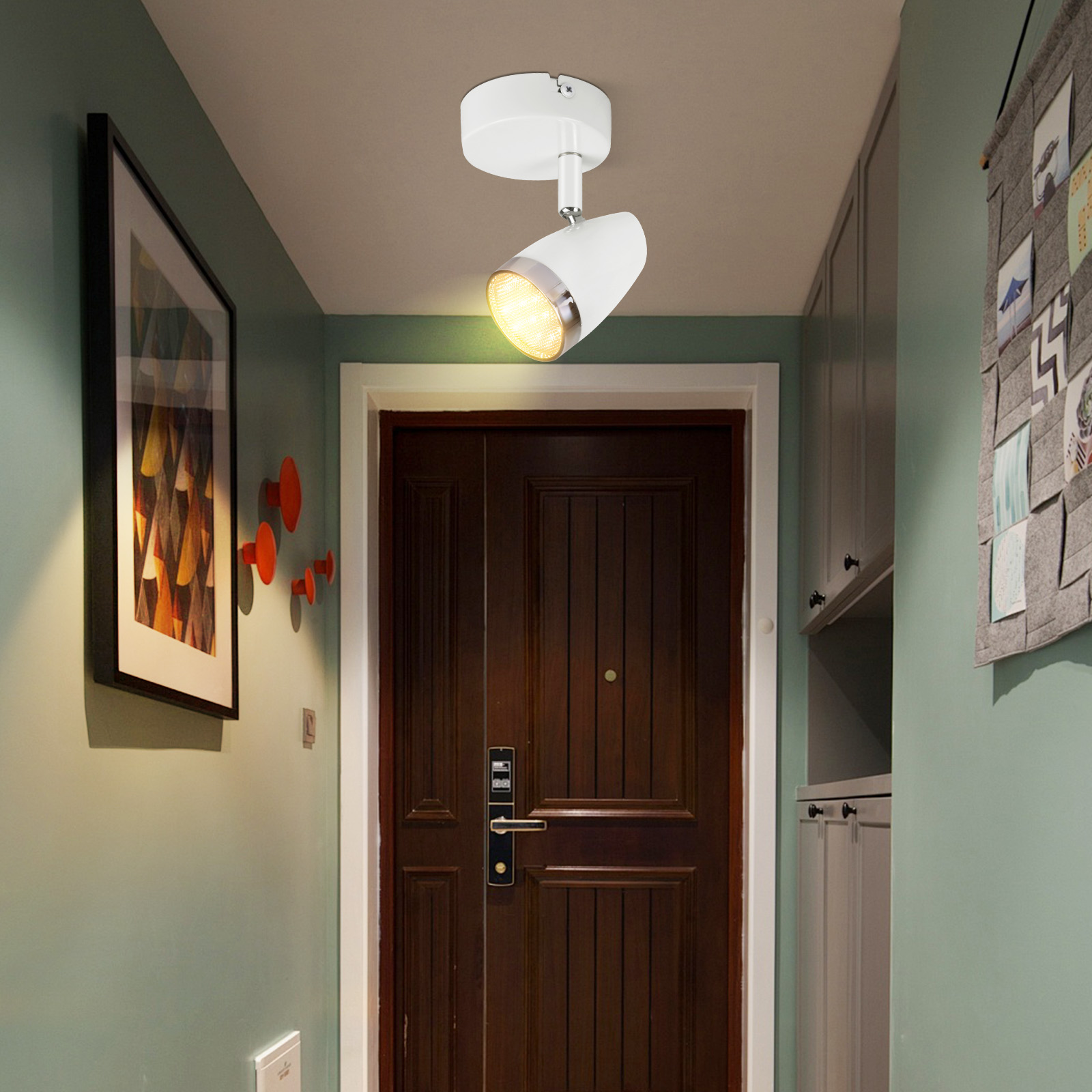 Korytarz z reflektorem. Jest ciemnobrązowe drzwi i sztuka na ścianie.