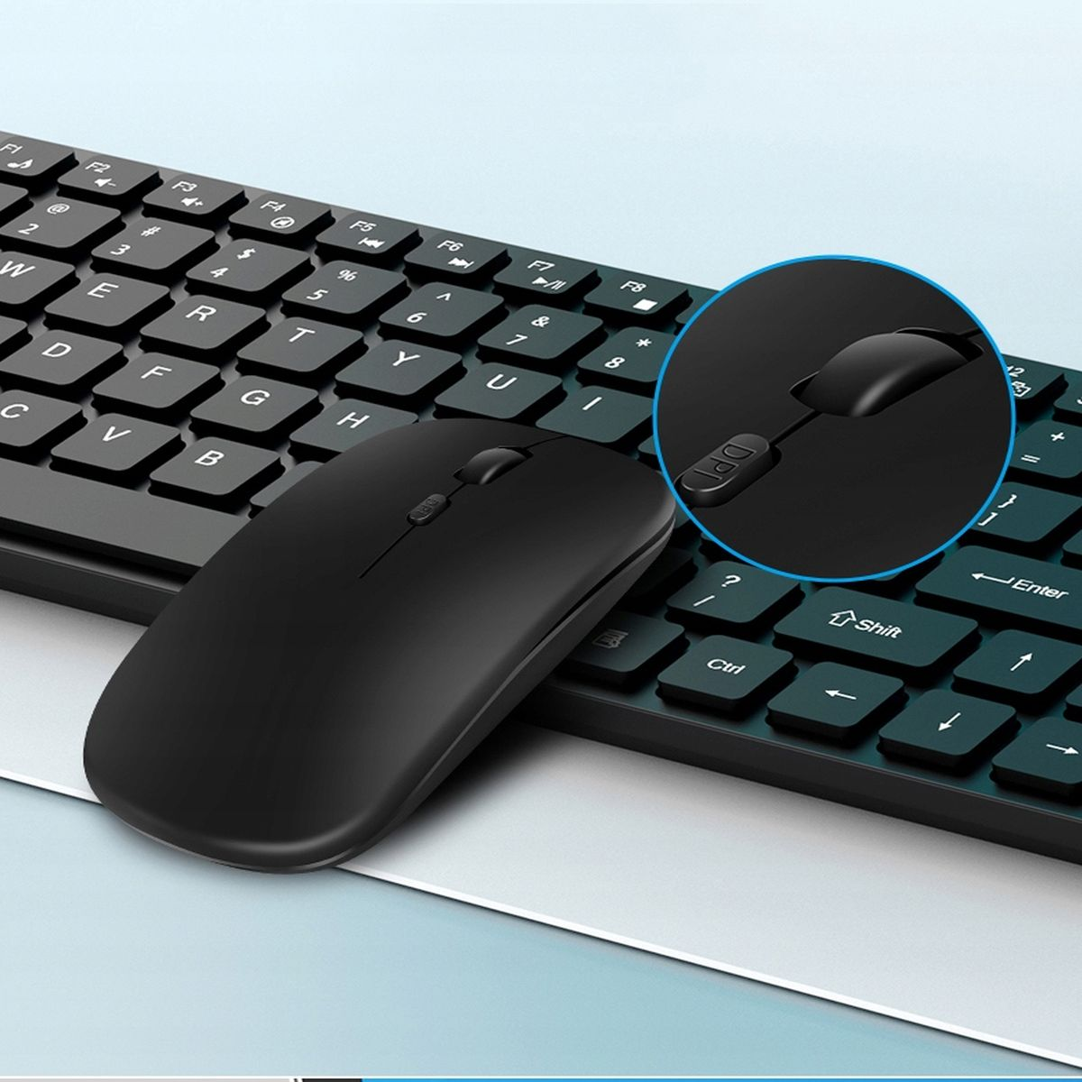 Czarna mysz leży na klawiaturze. Klawiatura jest czarna z białymi klawiszami. Tło jest niebieskie.