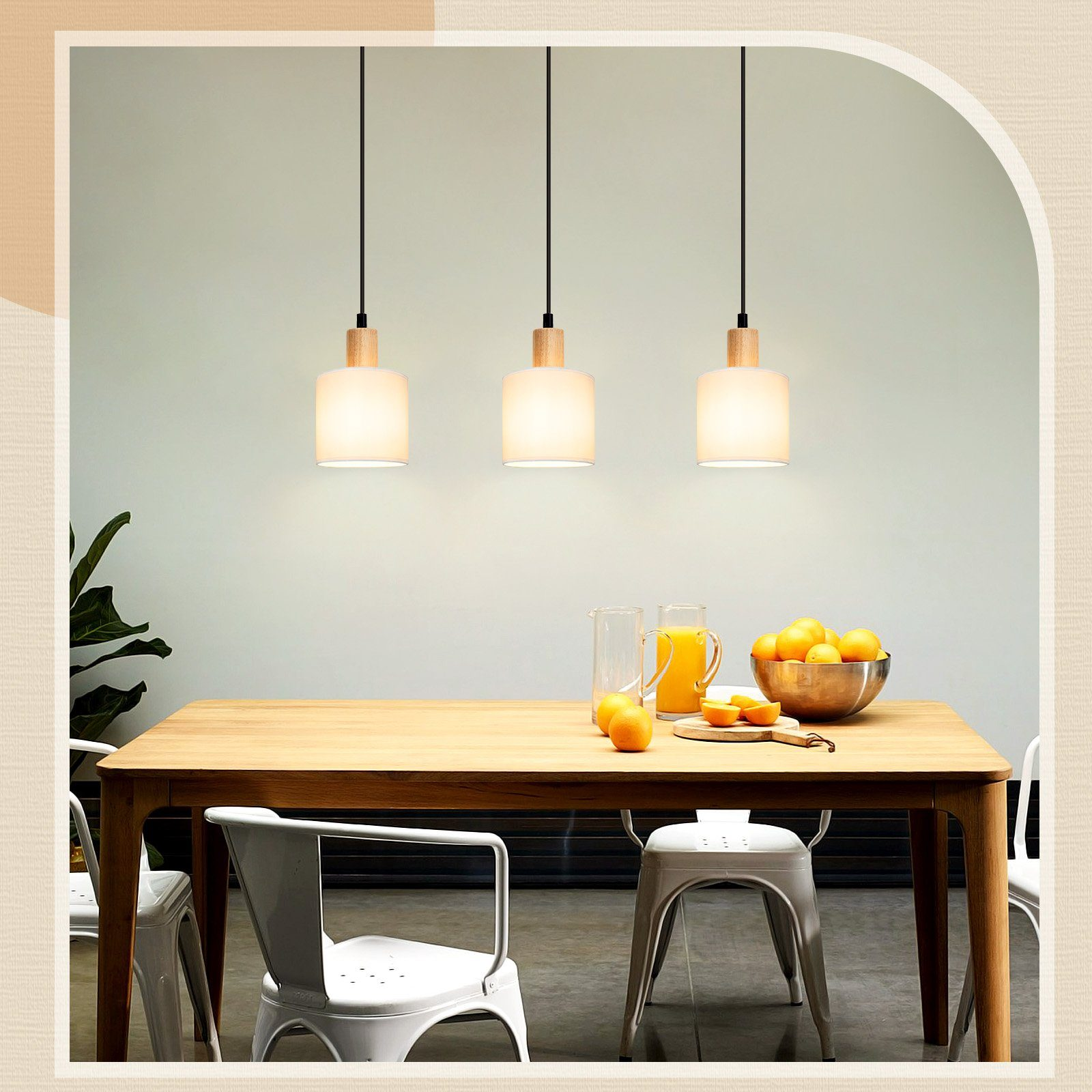 Esszimmer mit drei Pendelleuchten. Ein Holztisch ist mit Orangen und Gläsern gedeckt.
