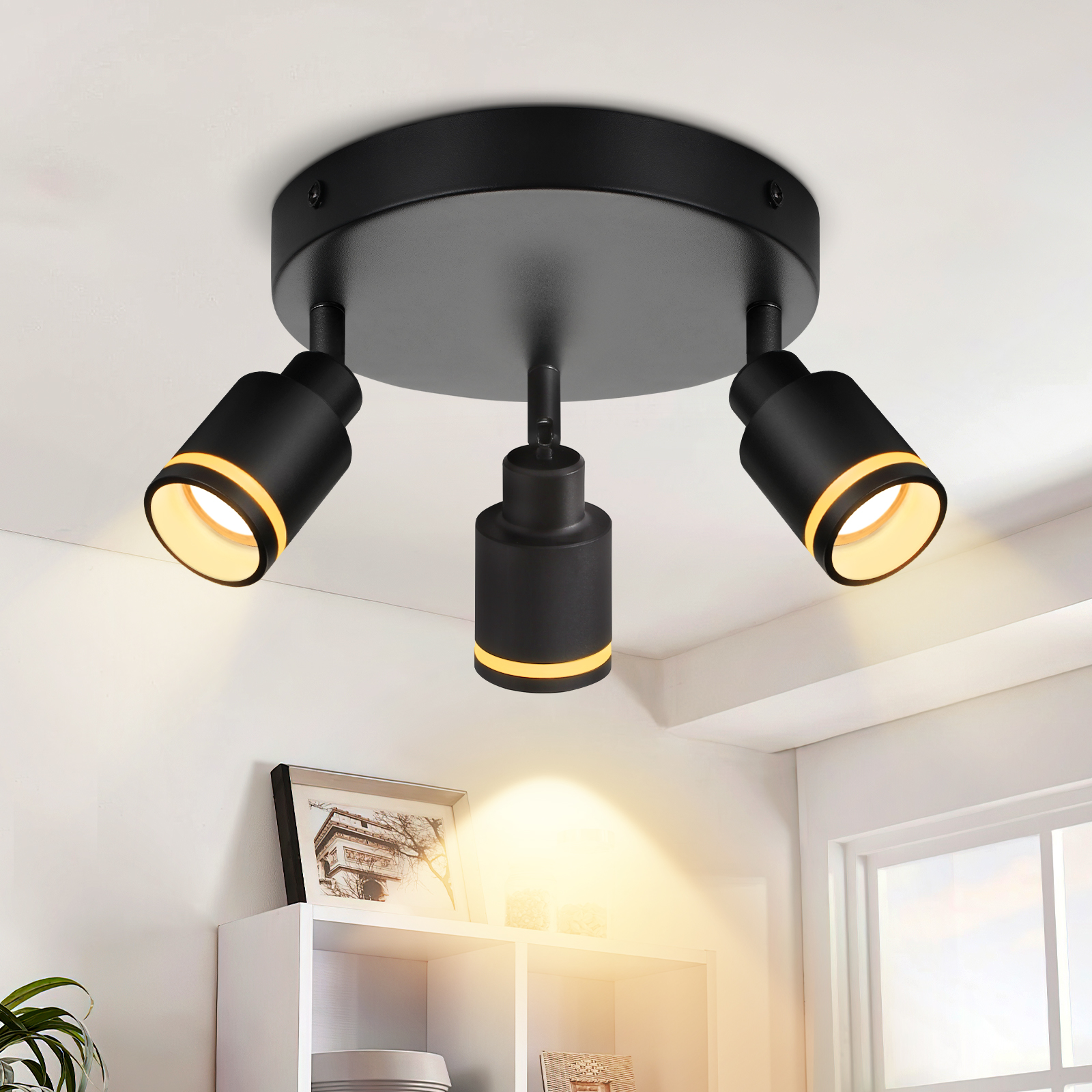 Faretto nero da soffitto con tre luci. Ogni luce è cilindrica, rivolta verso il basso.