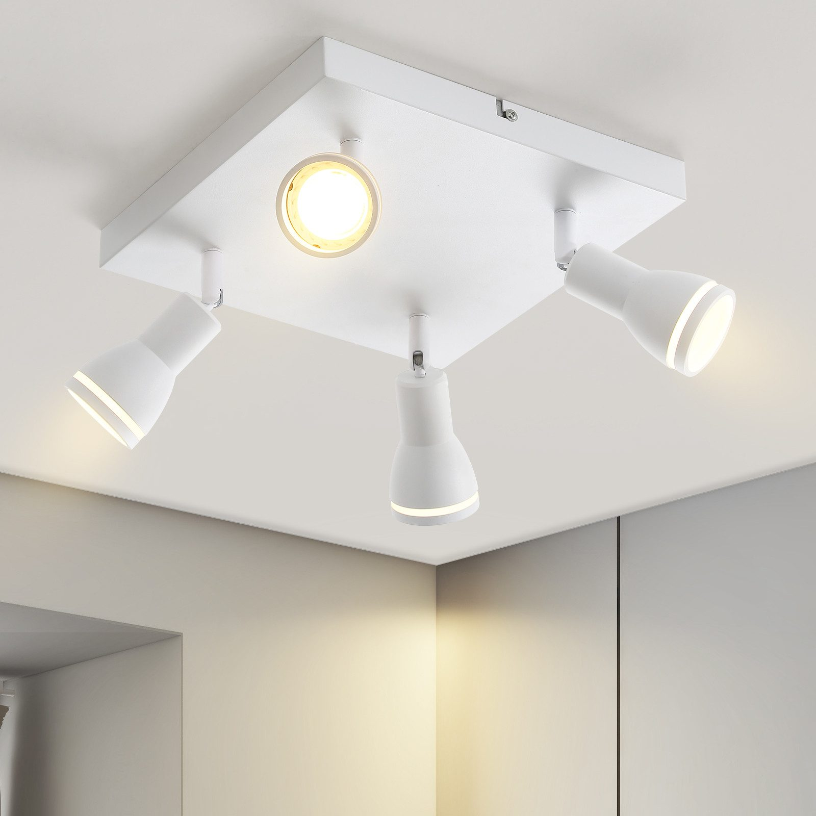 Plafoniera bianca con quattro faretti regolabili. Montata su un soffitto bianco.