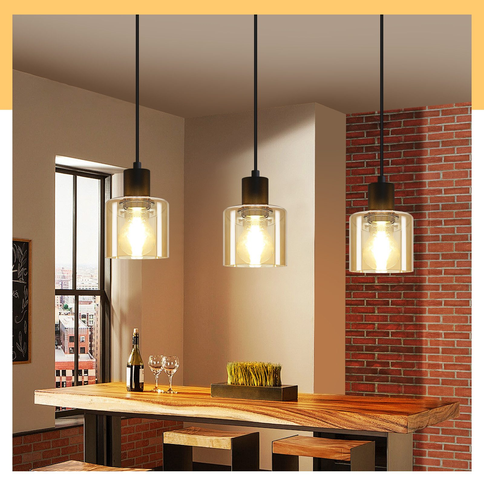 Tre lampade a sospensione in vetro con una luce calda in un ambiente cucina.