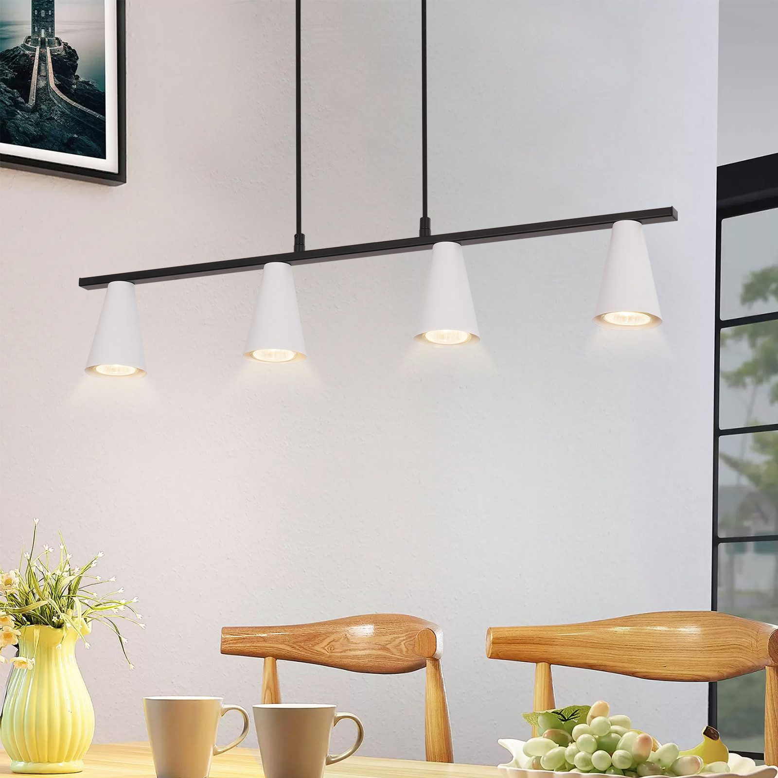 Una sala da pranzo con una lampada a sospensione lineare nera. Sono visibili quattro lampade bianche a forma di cono.