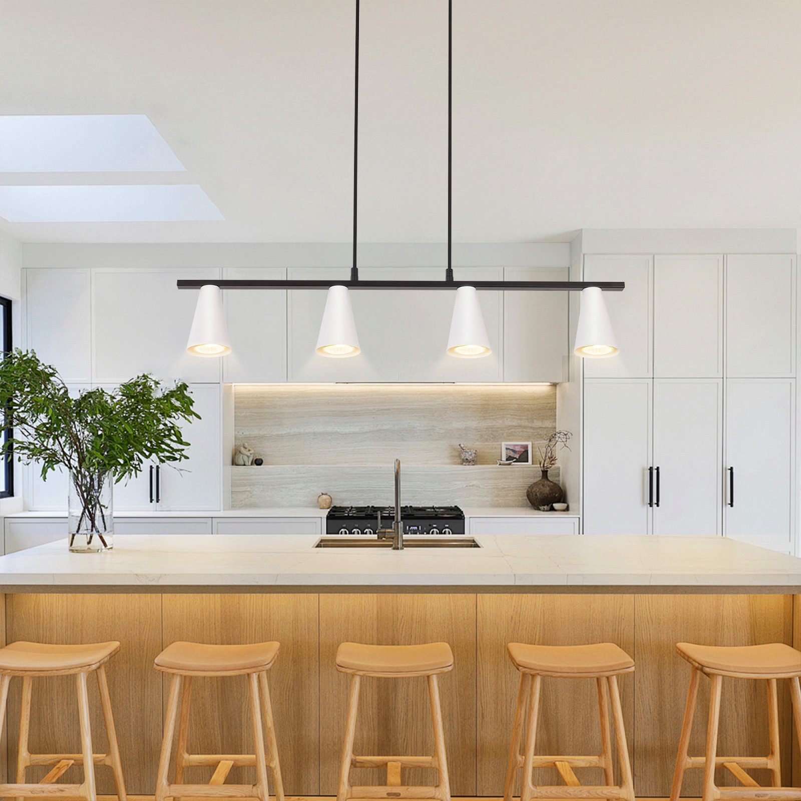 Una cucina con una lampada a sospensione lineare nera con quattro lampade bianche a forma di cono. Sono presenti sgabelli da bar in legno.