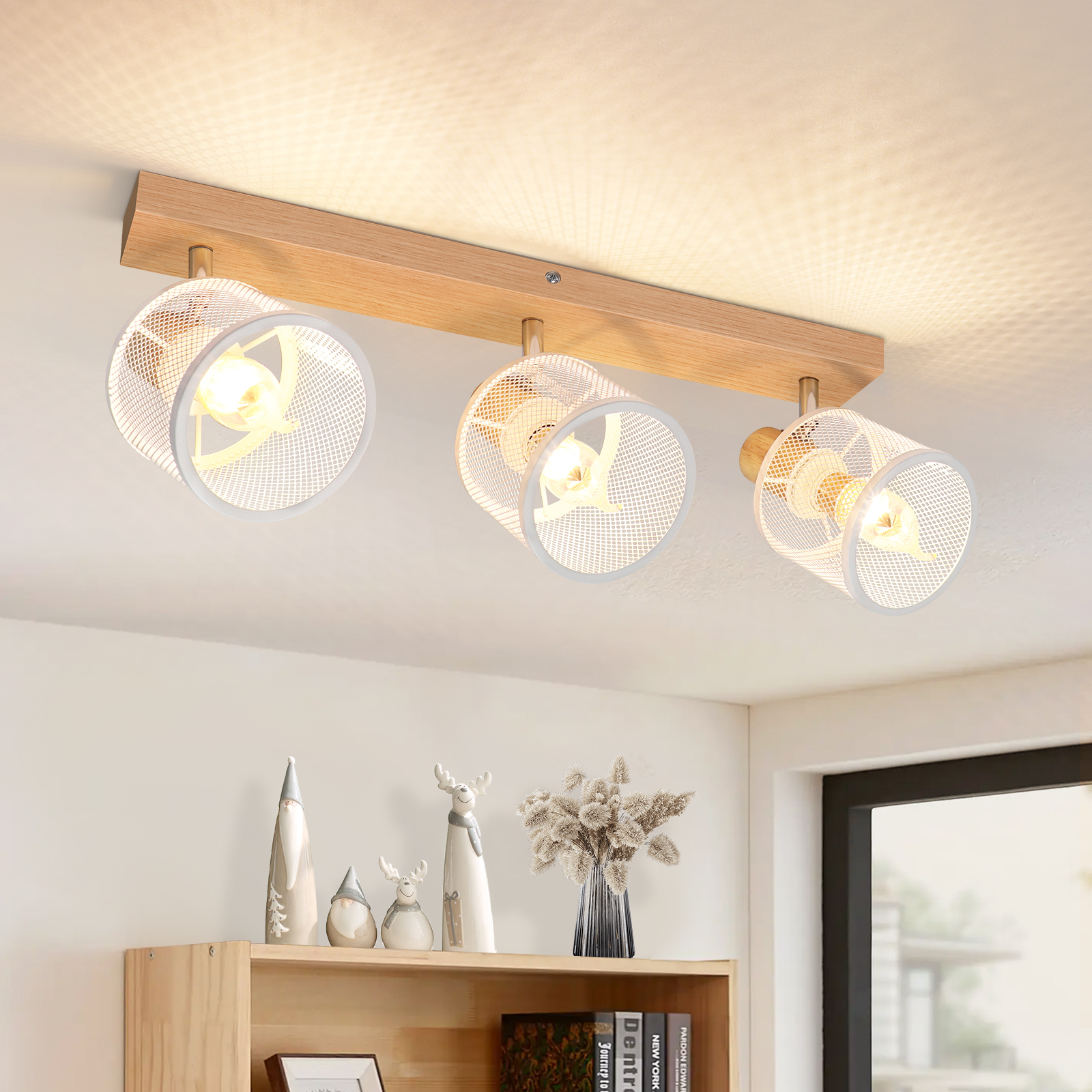 Trave in legno con tre faretti bianchi e decorazioni su uno scaffale.