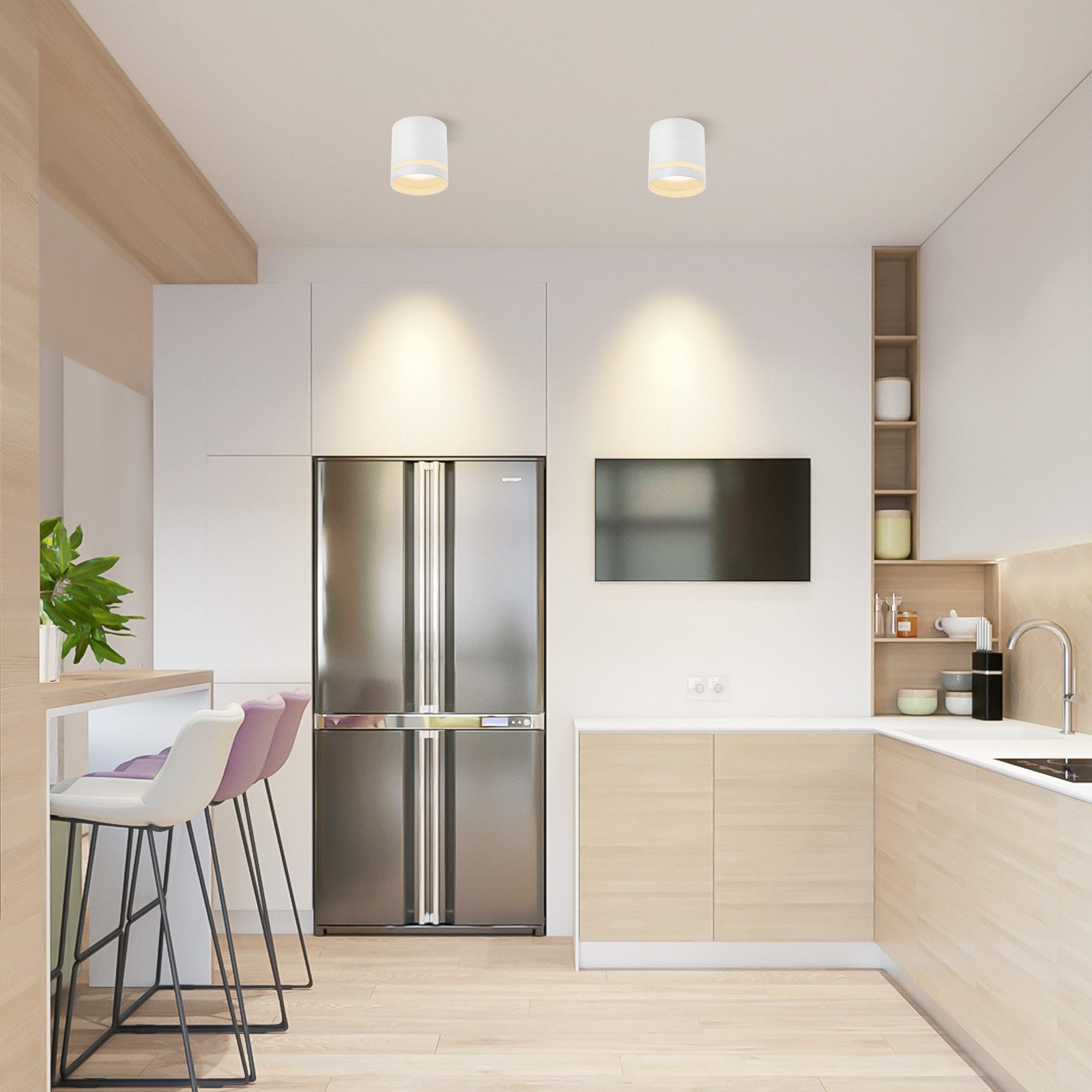 Cucina moderna con frigorifero in acciaio inossidabile, mobili in legno e sgabelli da bar. Due luci a soffitto.