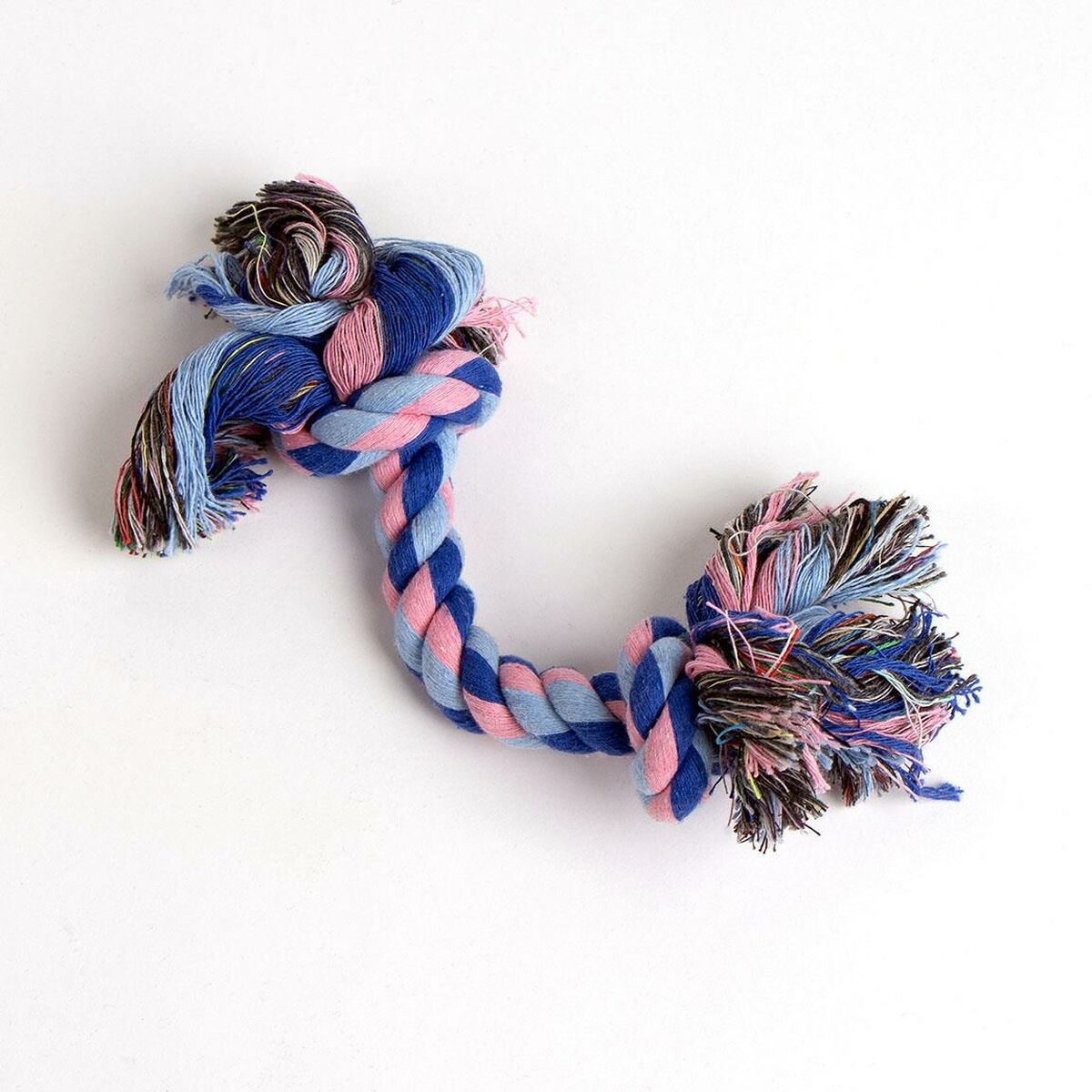 Un giocattolo per cani fatto di corda intrecciata blu e rosa. Sfondo bianco.