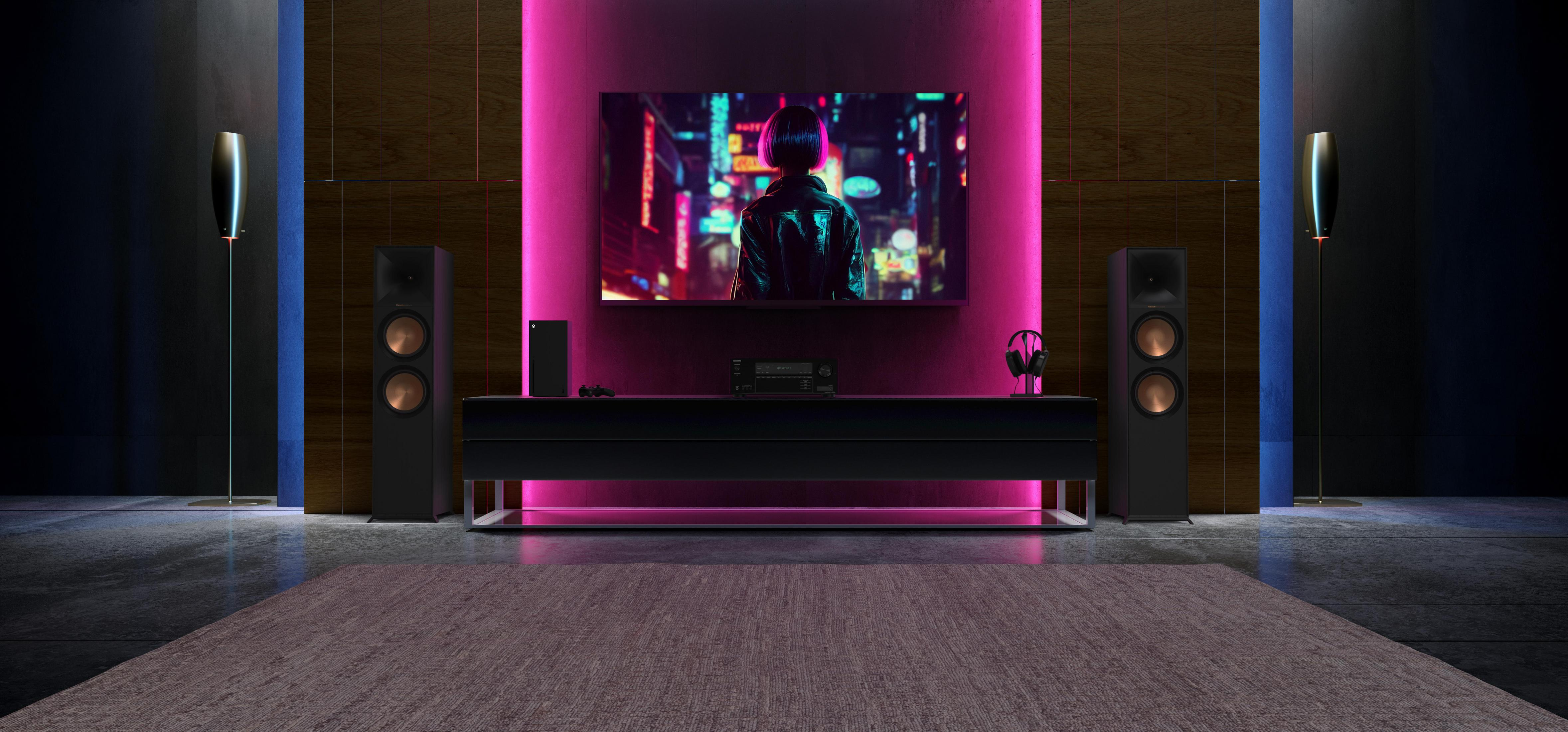 Wohnzimmer mit Fernseher, schwarzen Lautsprechern, einem schwarzen Tisch mit Konsole und lila Licht.