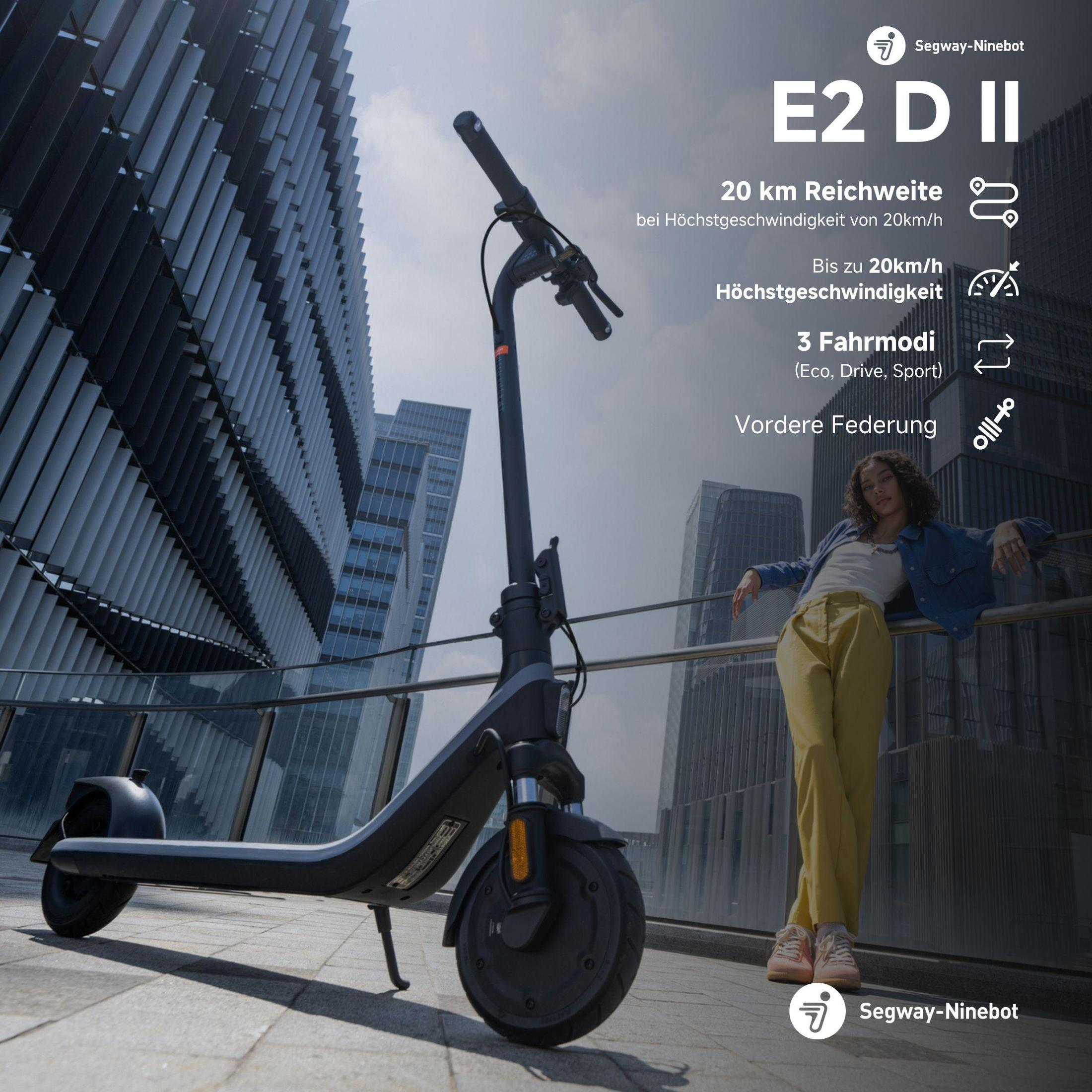 Eine Frau lehnt an einem Geländer neben einem Elektroroller. Der Roller ist schwarz und grau.