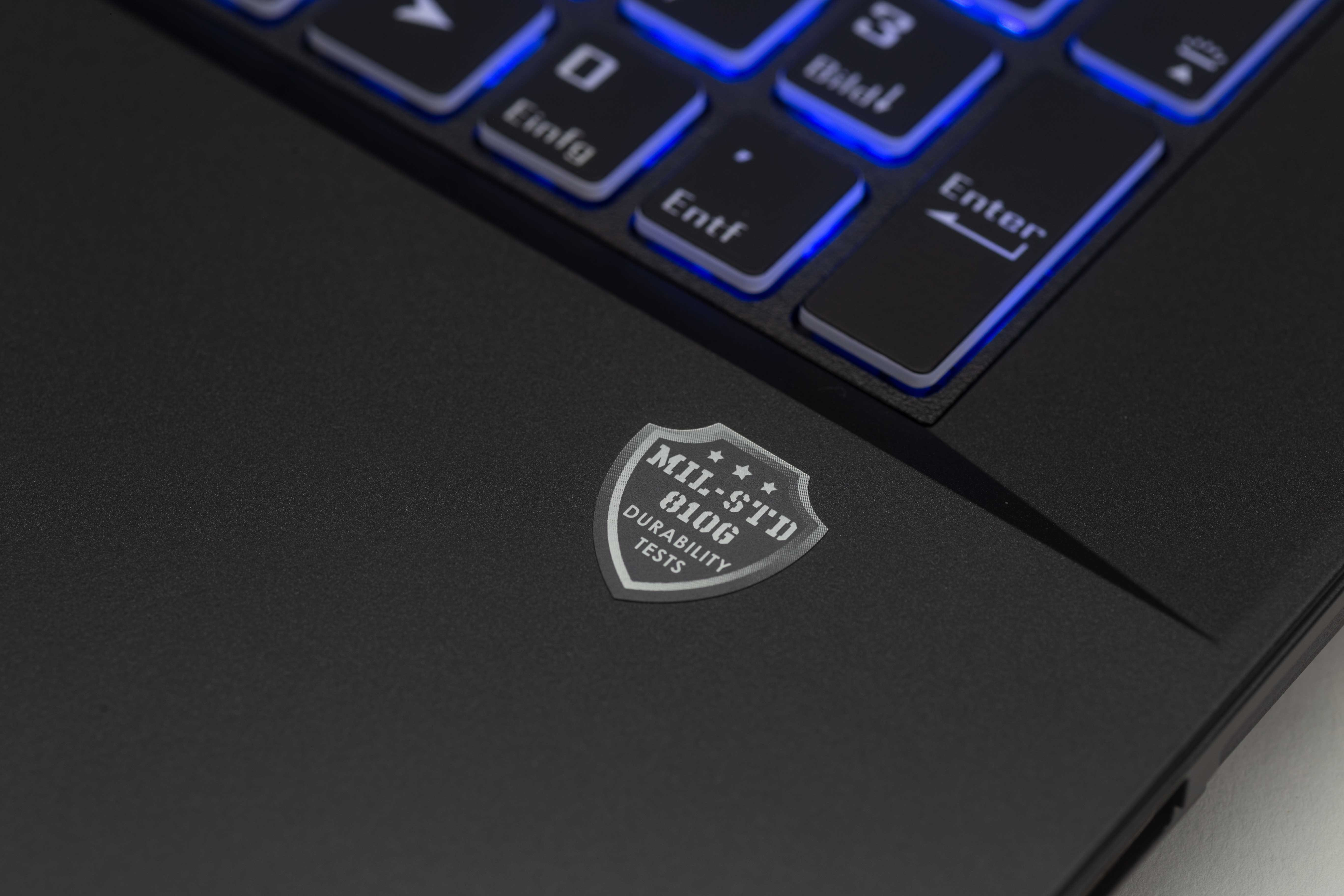 Zbliżenie klawiatury laptopa z naklejką MIL-STD 810G.