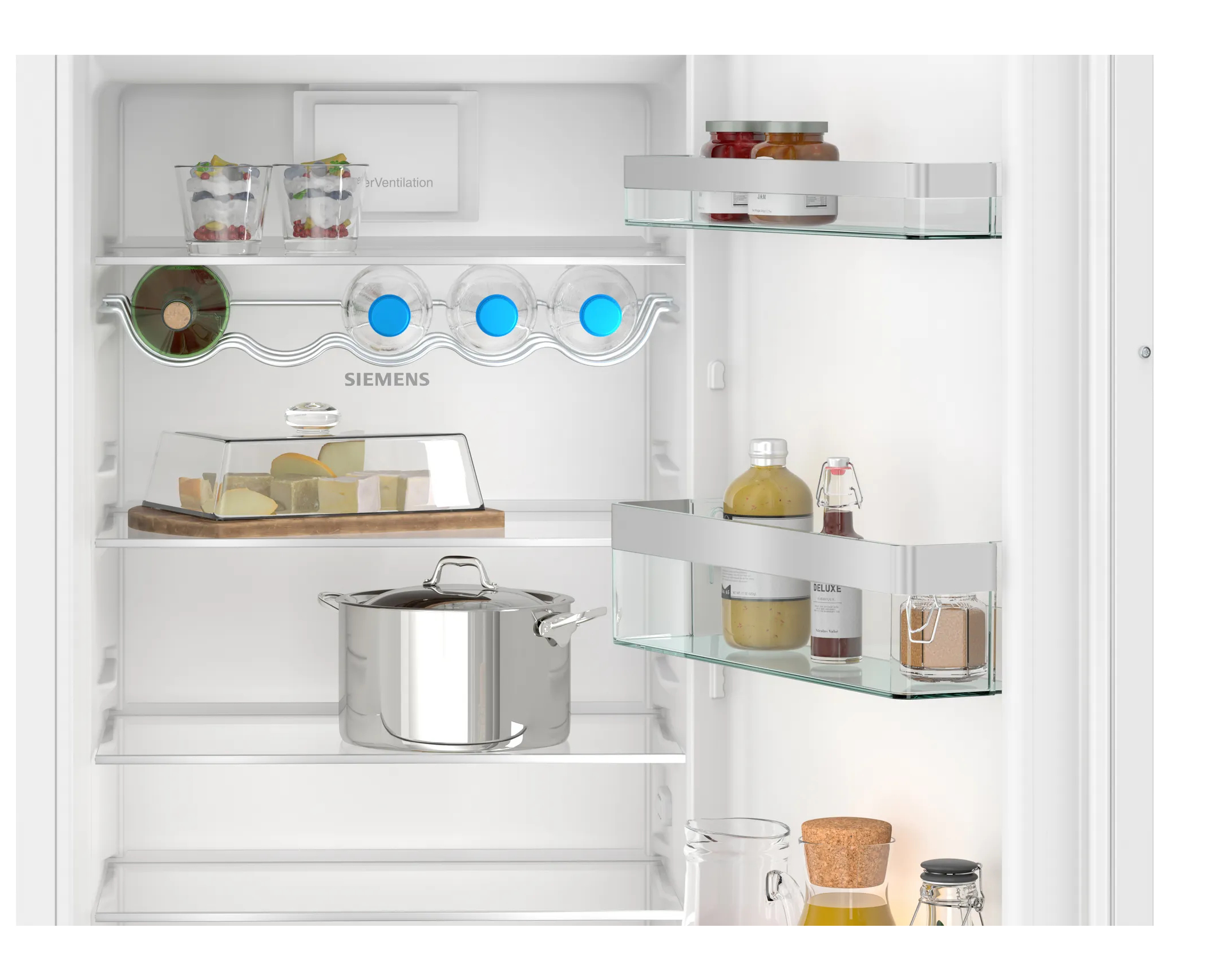 Wewnątrz lodówki: półki z produktami spożywczymi, w tym słoikami, butelkami i produktami.