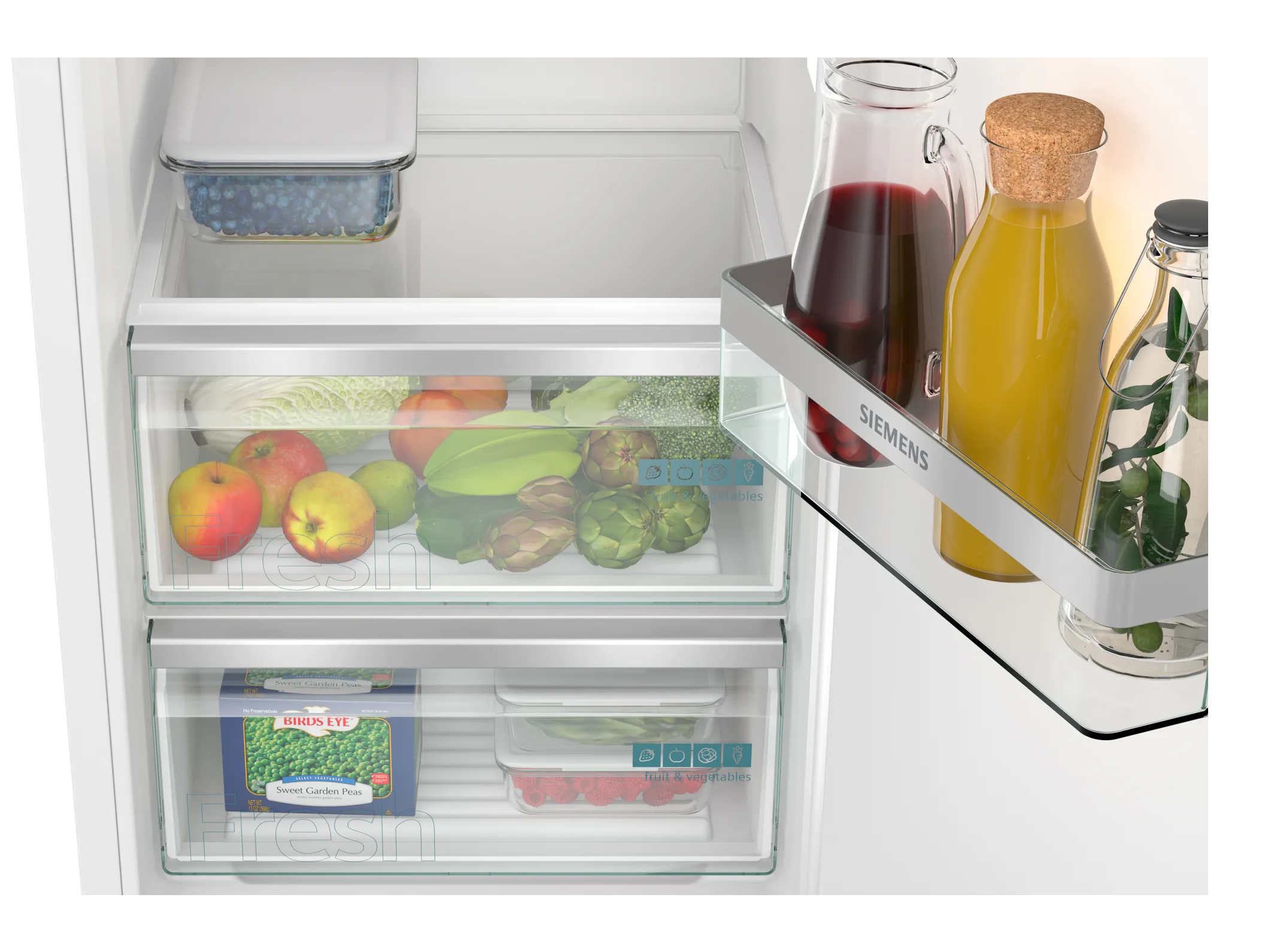 Wnętrze lodówki: owoce/warzywa w szufladach, płyny na półce. Świeża żywność, widoczne etykiety.
