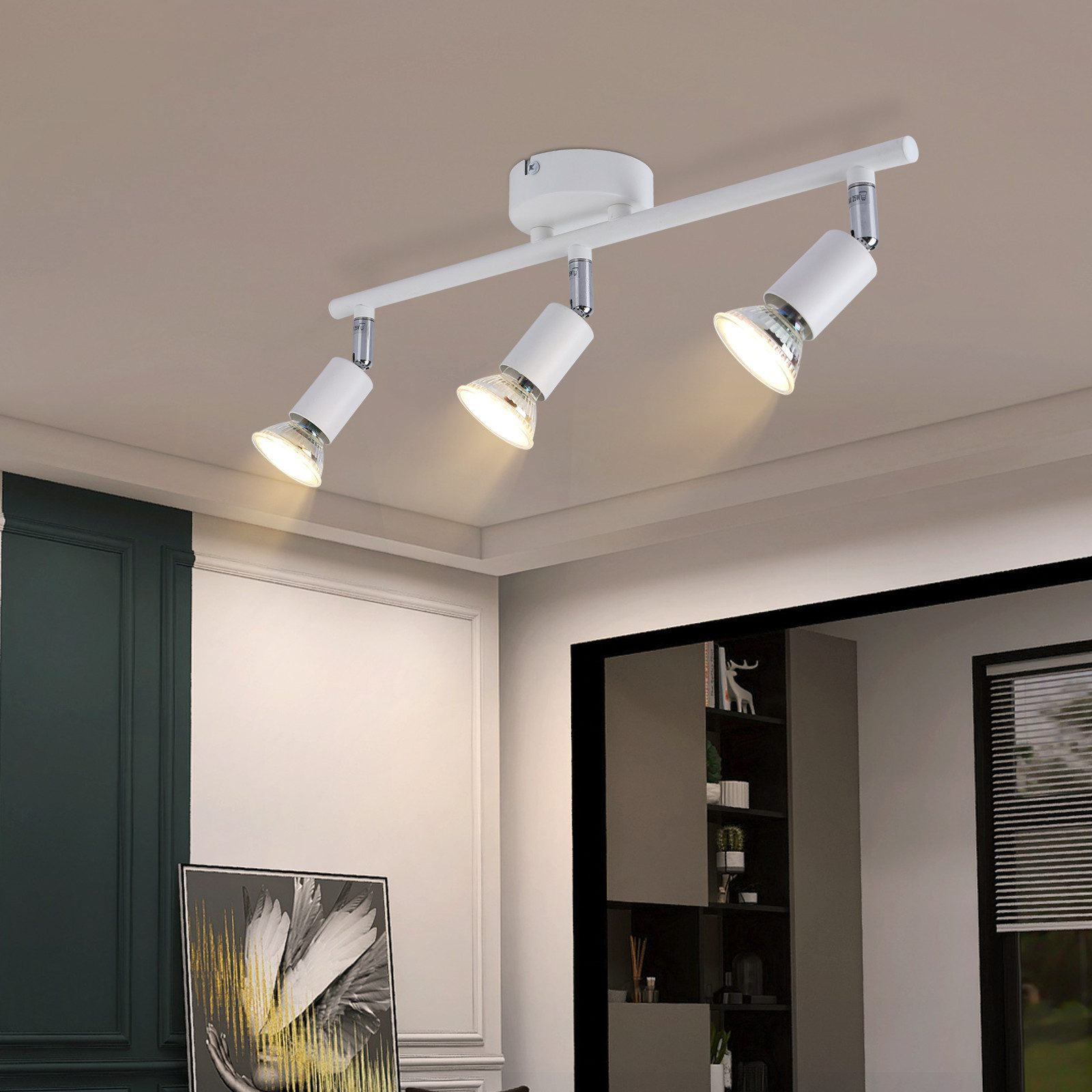 Tre faretti bianchi su una guida bianca sono montati su un soffitto bianco.