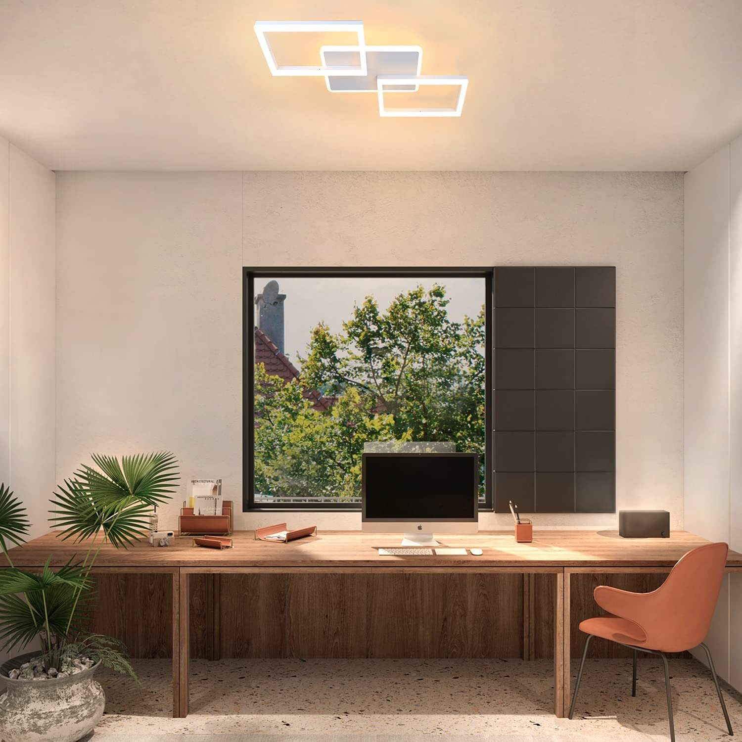 Büro mit Holztisch, Stuhl, Fenster und Deckenleuchten. Blick auf Bäume vor dem Fenster.