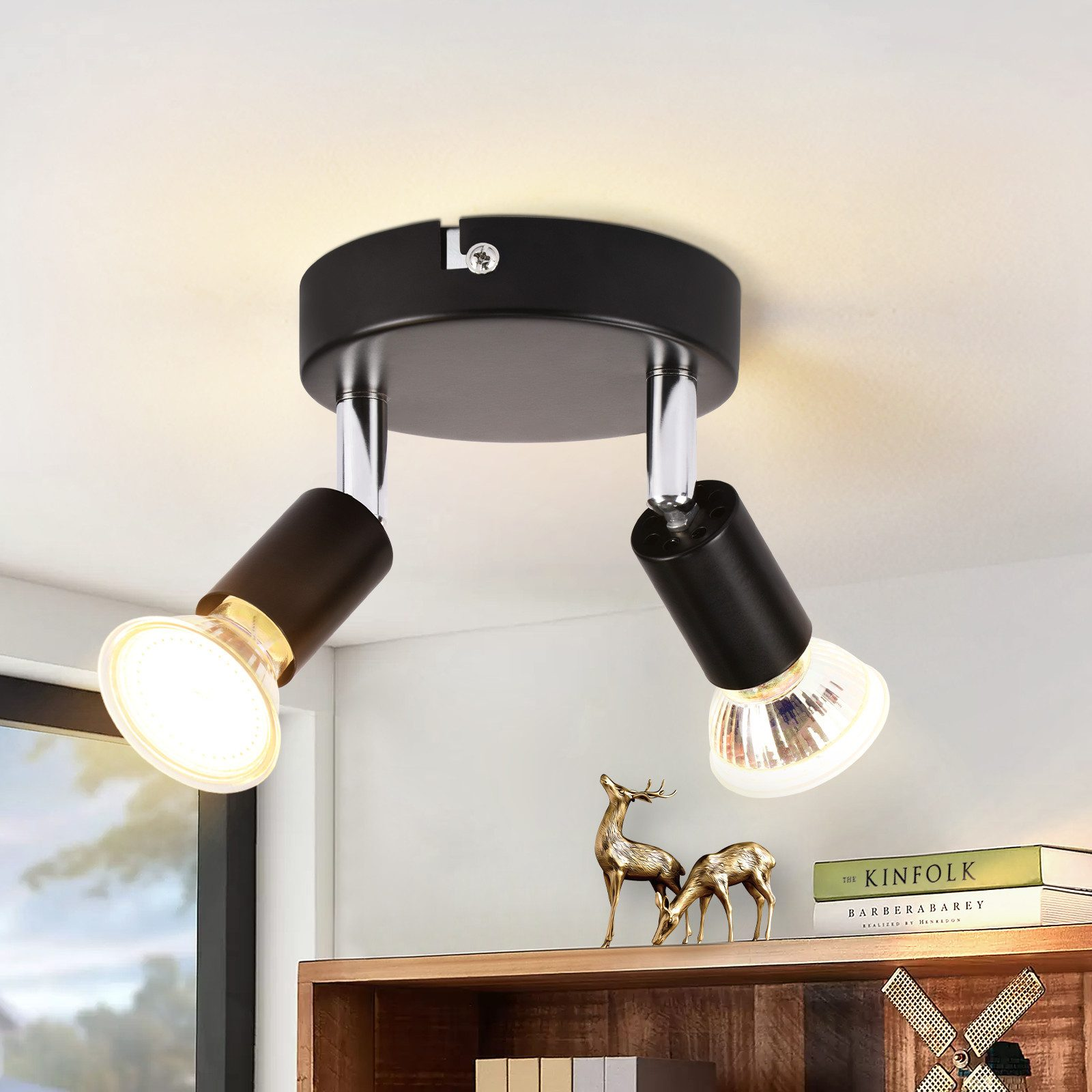 Faretto nero da soffitto con due lampade regolabili. Lo sfondo è un soffitto bianco.