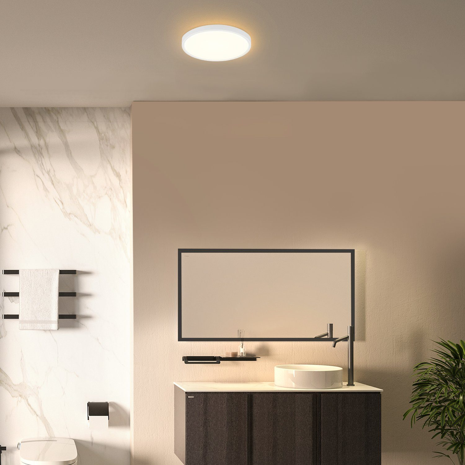 Badezimmer mit weißer Deckenleuchte, Spiegel, Waschbecken und Toilette. Beige und Marmor Wände. Grüne Pflanze.
