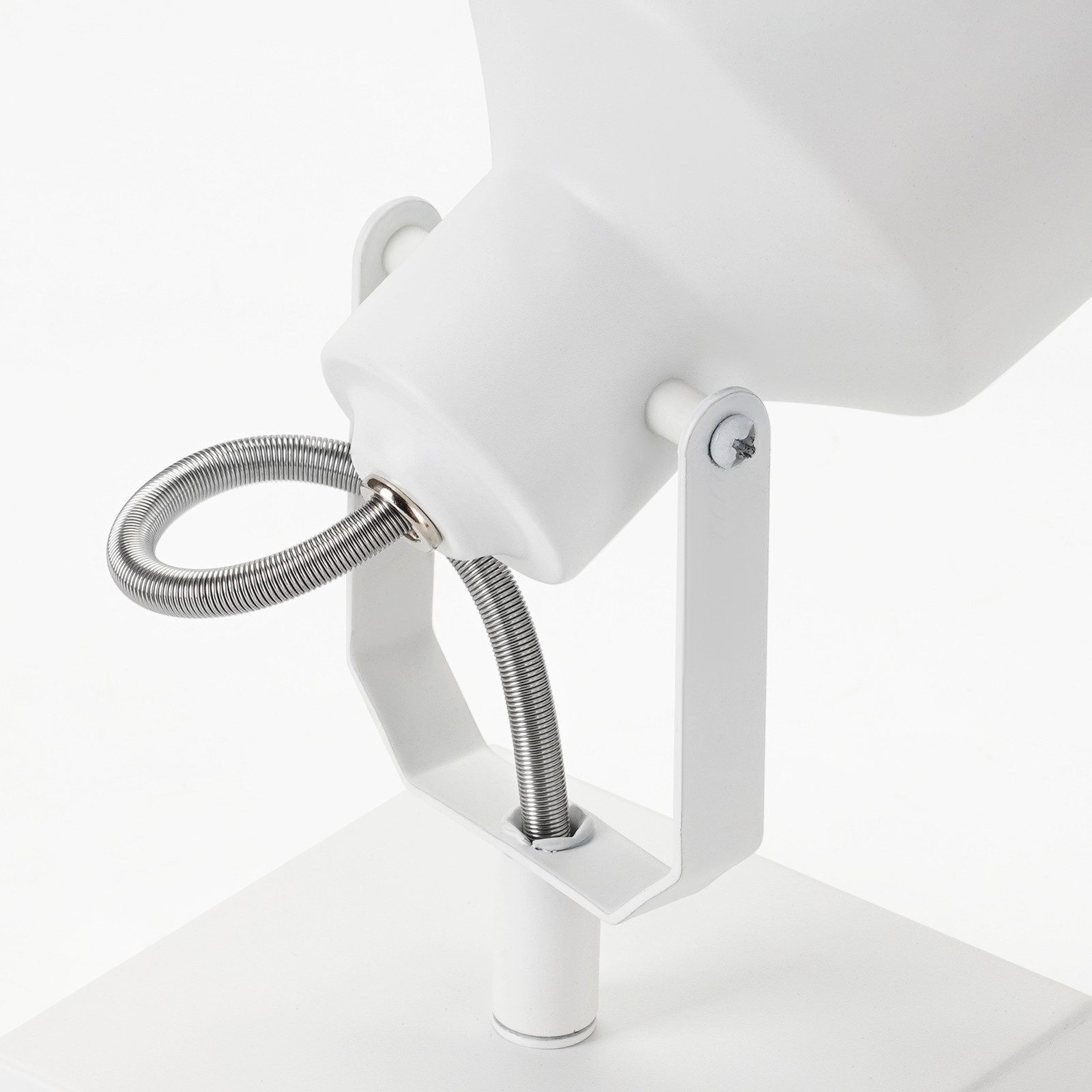 Zbliżenie białego reflektora. Pokazuje mocowanie i sprężynę.