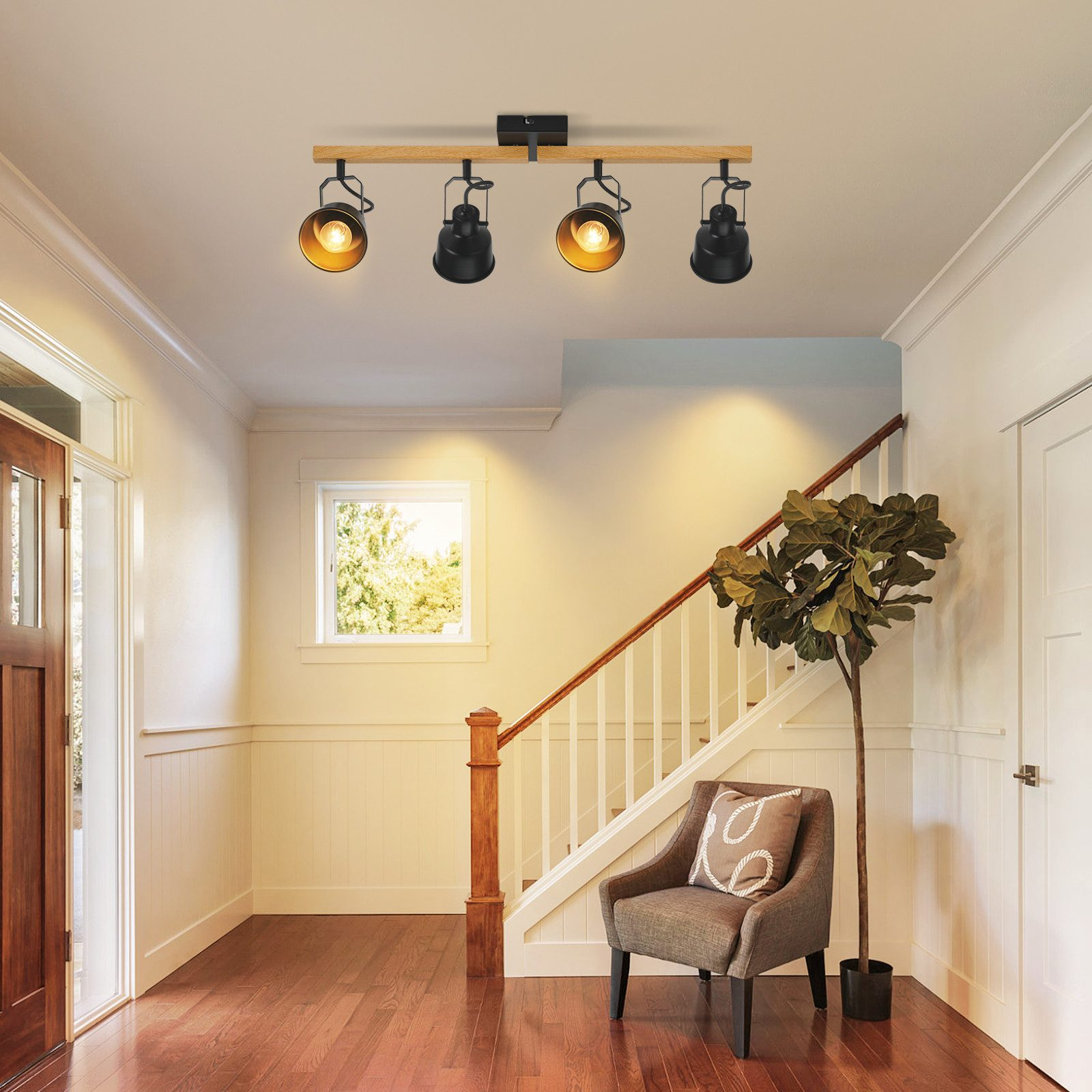 Korytarz ze schodami, krzesłem i oprawą oświetleniową na suficie.