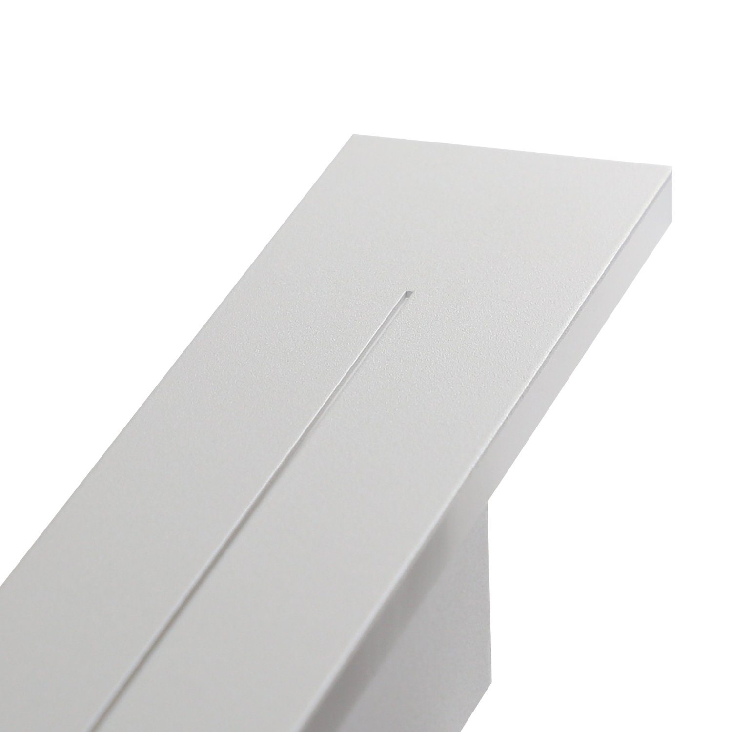 Primo piano di un oggetto bianco angolato con una scanalatura. L'oggetto sembra far parte di un design.