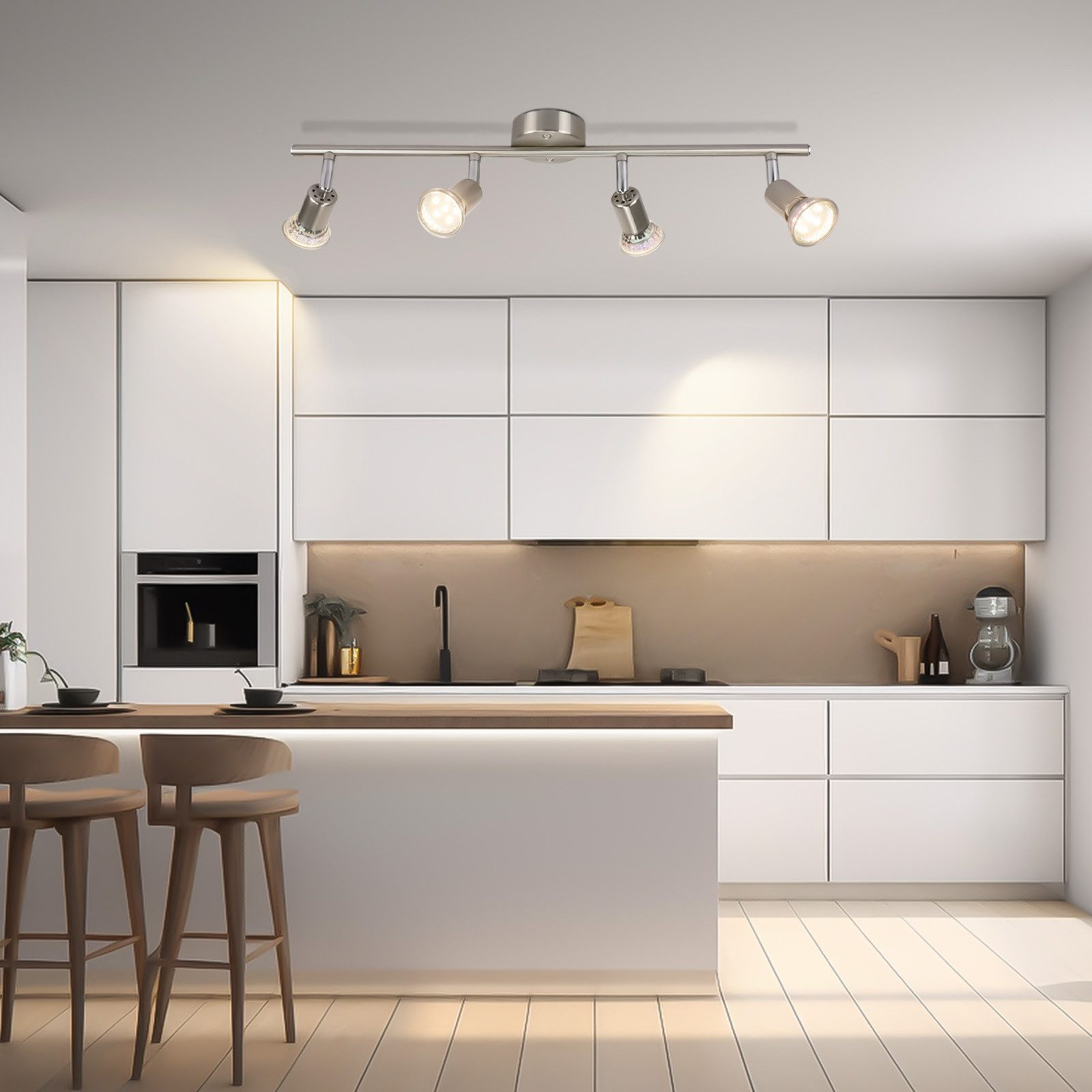 Kuchnia z białymi szafkami, drewnianym blatem i czterema reflektorami.