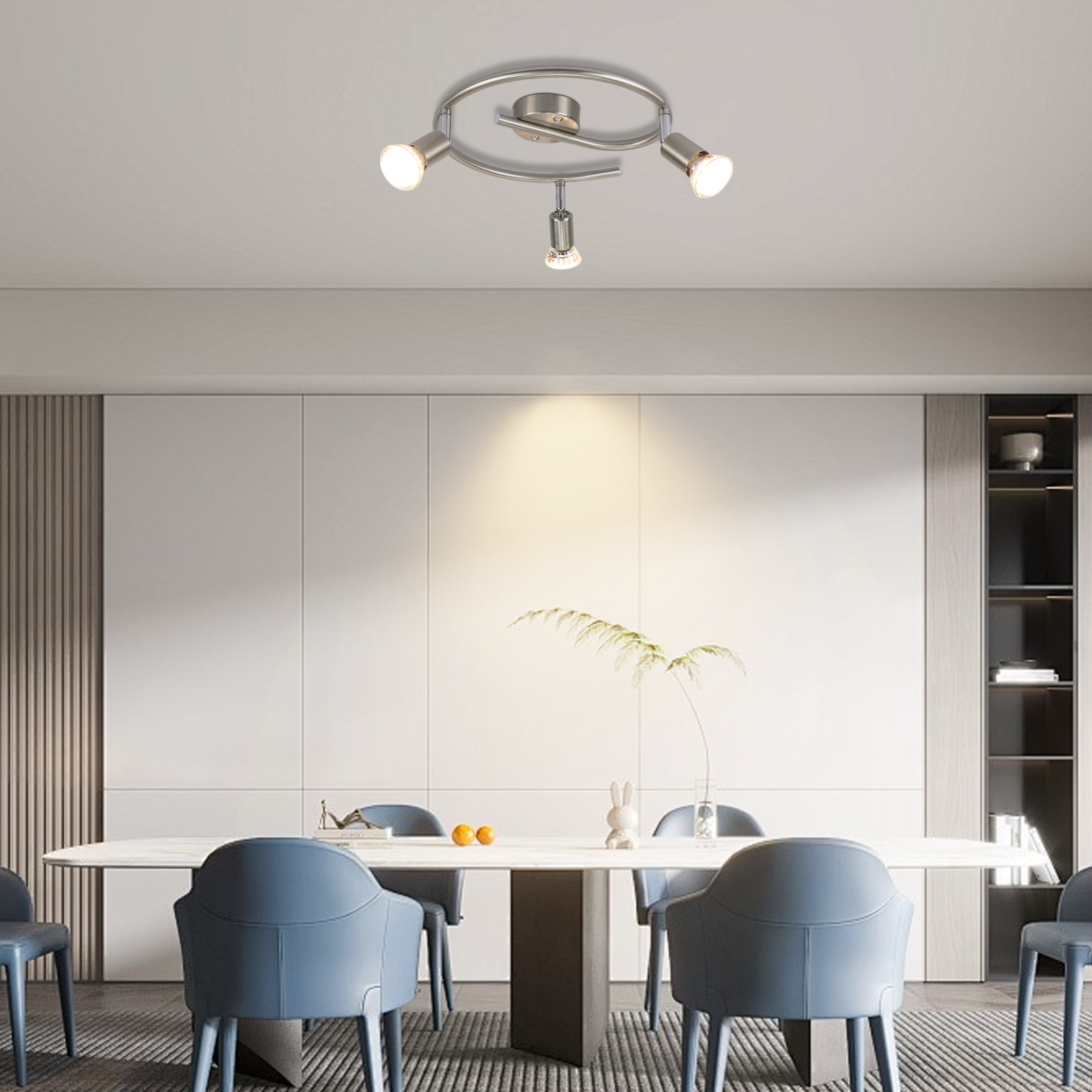 Nowoczesna jadalnia z lampą sufitową nad długim stołem i krzesłami.