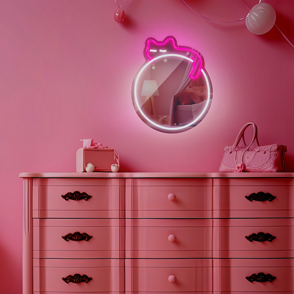 Decoración de dormitorio rosa con cómoda, espejo y letrero de gato de neón. Un bolso está en la cómoda.