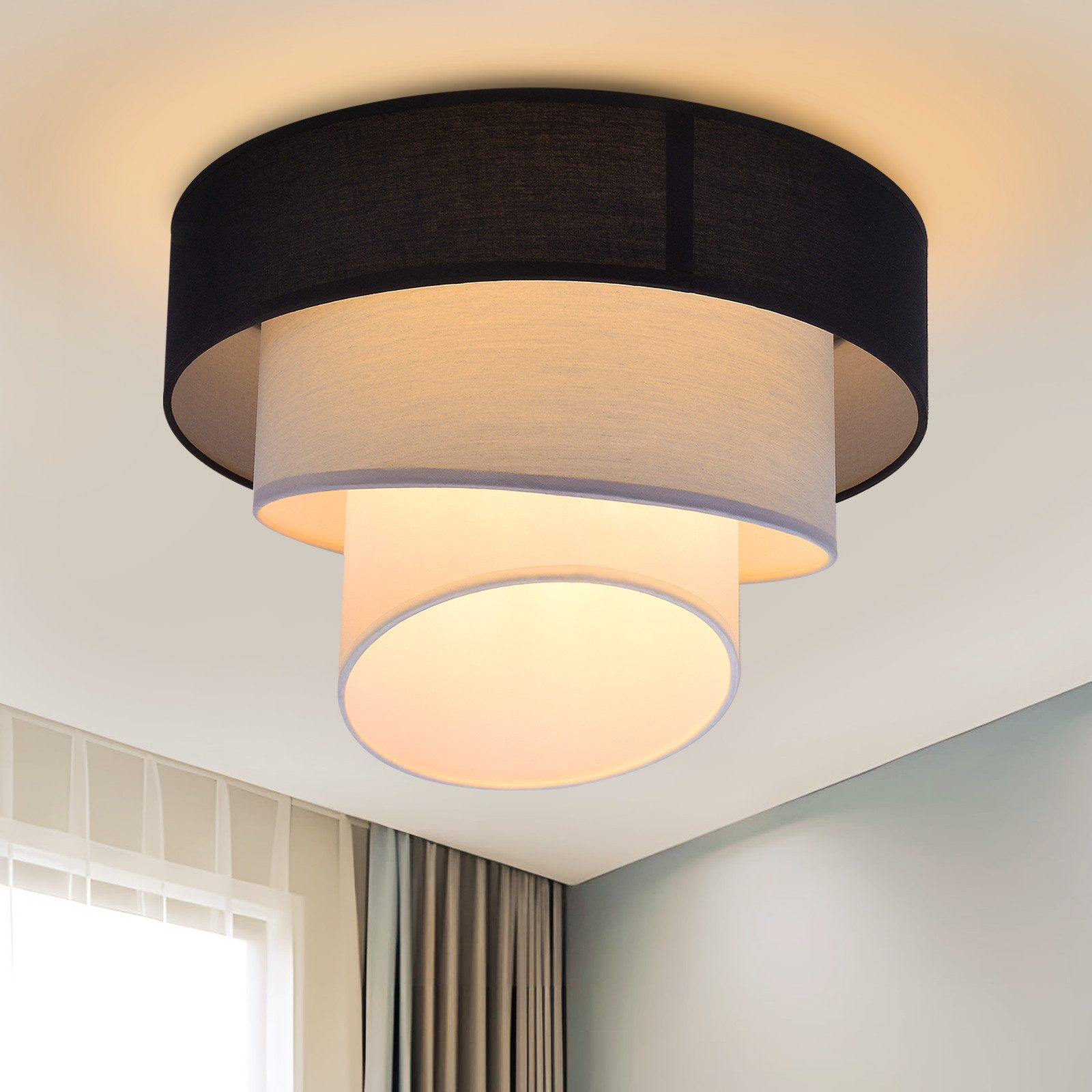 Lampada da soffitto rotonda con tre paralumi, soffitto bianco.