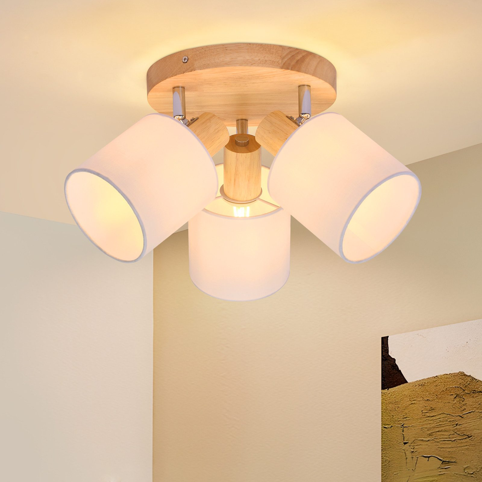 Apparecchio di illuminazione a soffitto con tre paralumi bianchi e una base in legno, montato su un soffitto bianco.