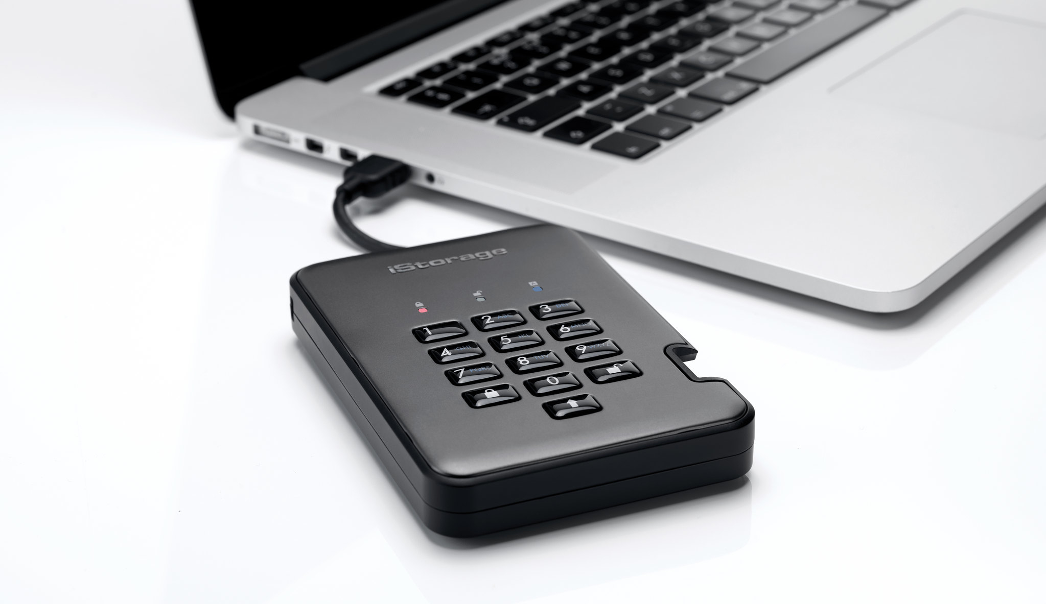 Czarny dysk twardy iStorage podłączony do laptopa za pomocą kabla.