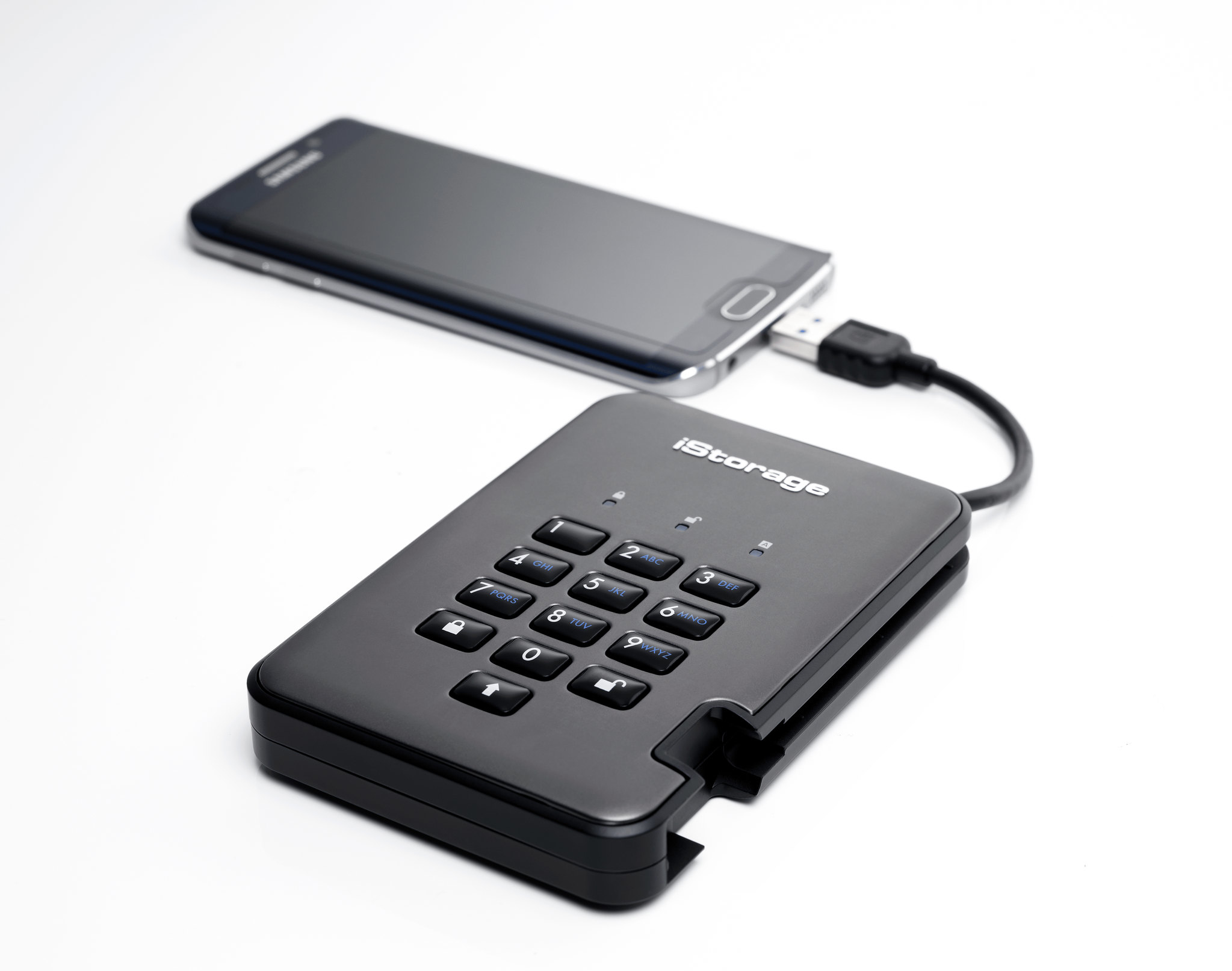 Hard disk esterno nero collegato a un telefono tramite cavo USB su sfondo bianco.