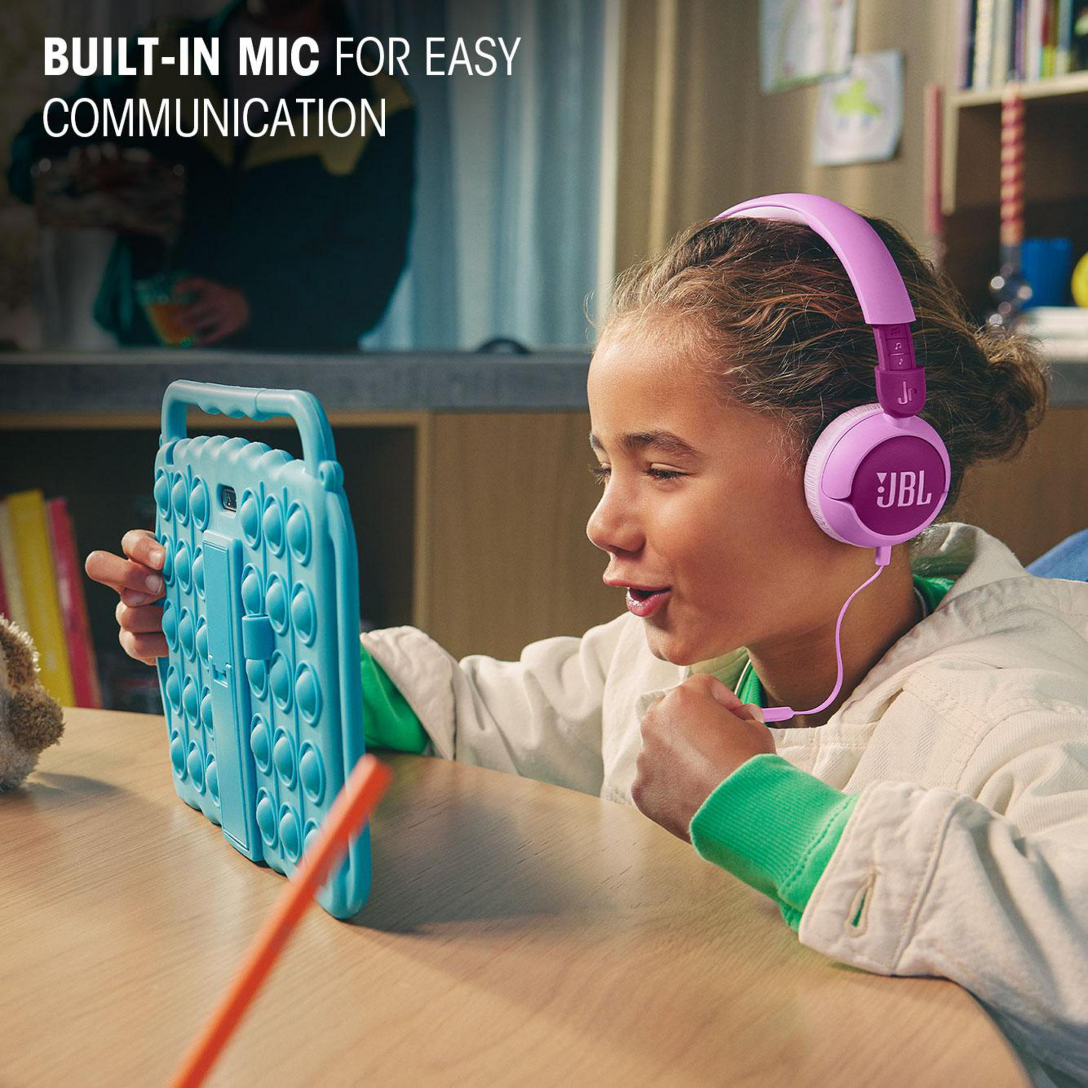 Una niña con auriculares rosas mira una tableta azul con burbujas pop-it.