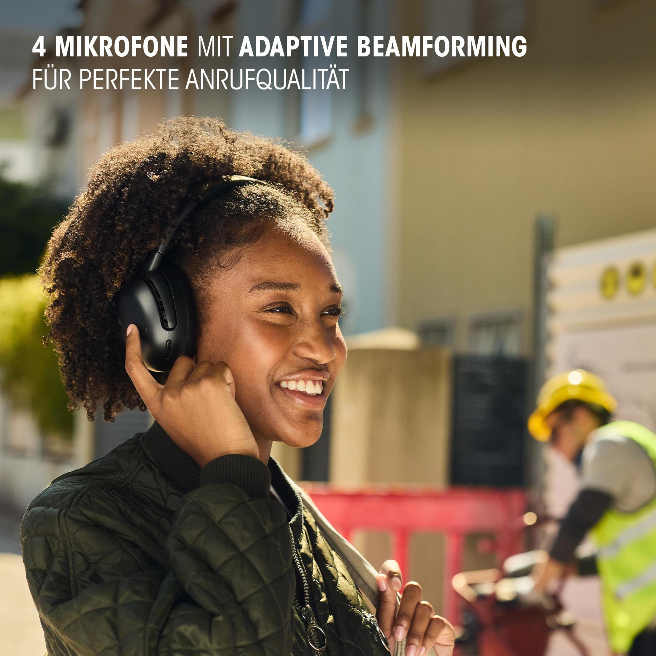Donna con cuffie nere, sorridente all'aperto. Testo sul beamforming adattivo.