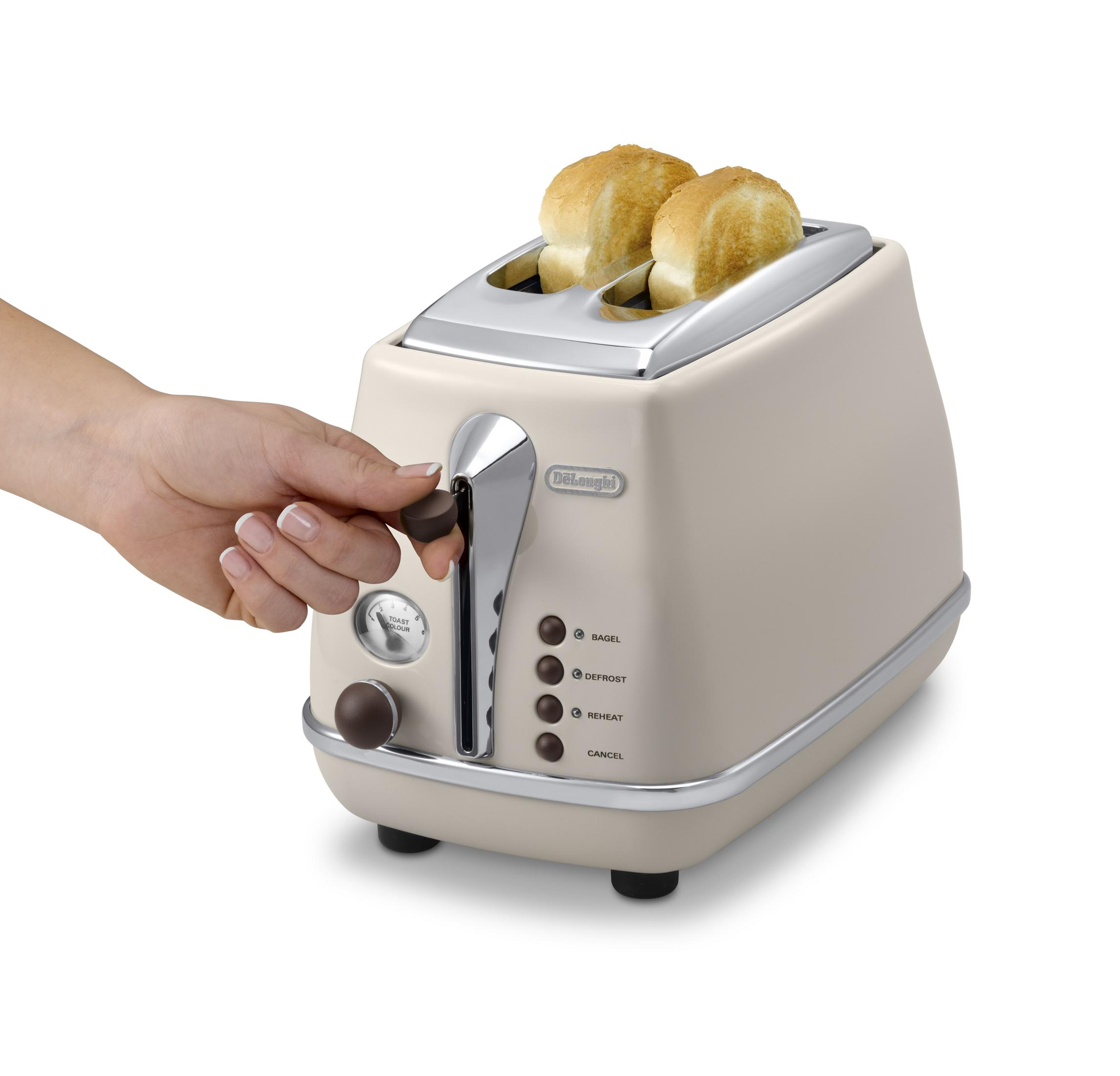 El, krem rengi bir DeLonghi tost makinesine ekmek yerleştiriyor. Düğmeleri, bir kadranı ve marka adını içerir.
