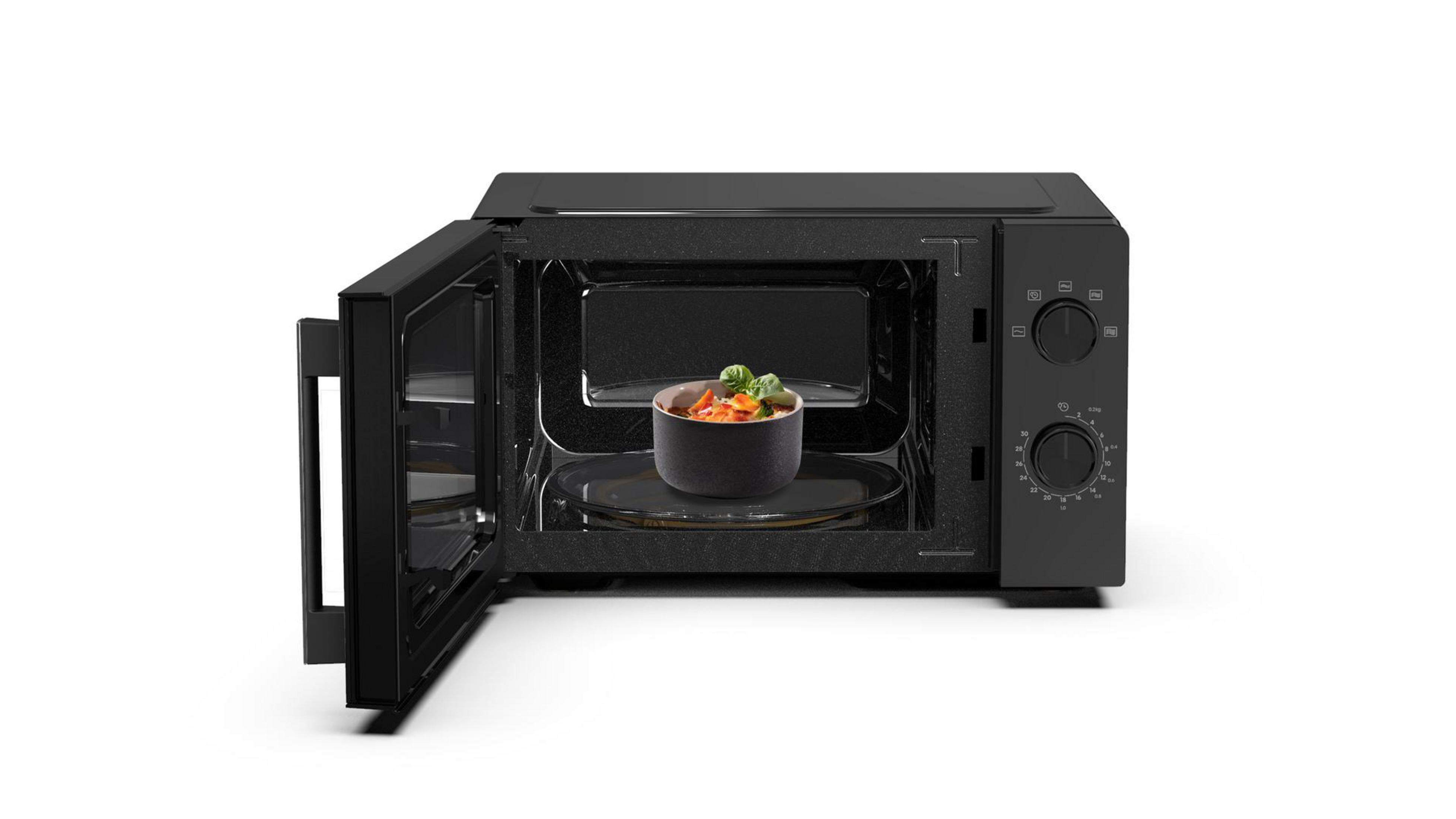 Kuchenka mikrofalowa z otwartymi drzwiami. Miska z jedzeniem na szklanym talerzu w środku.