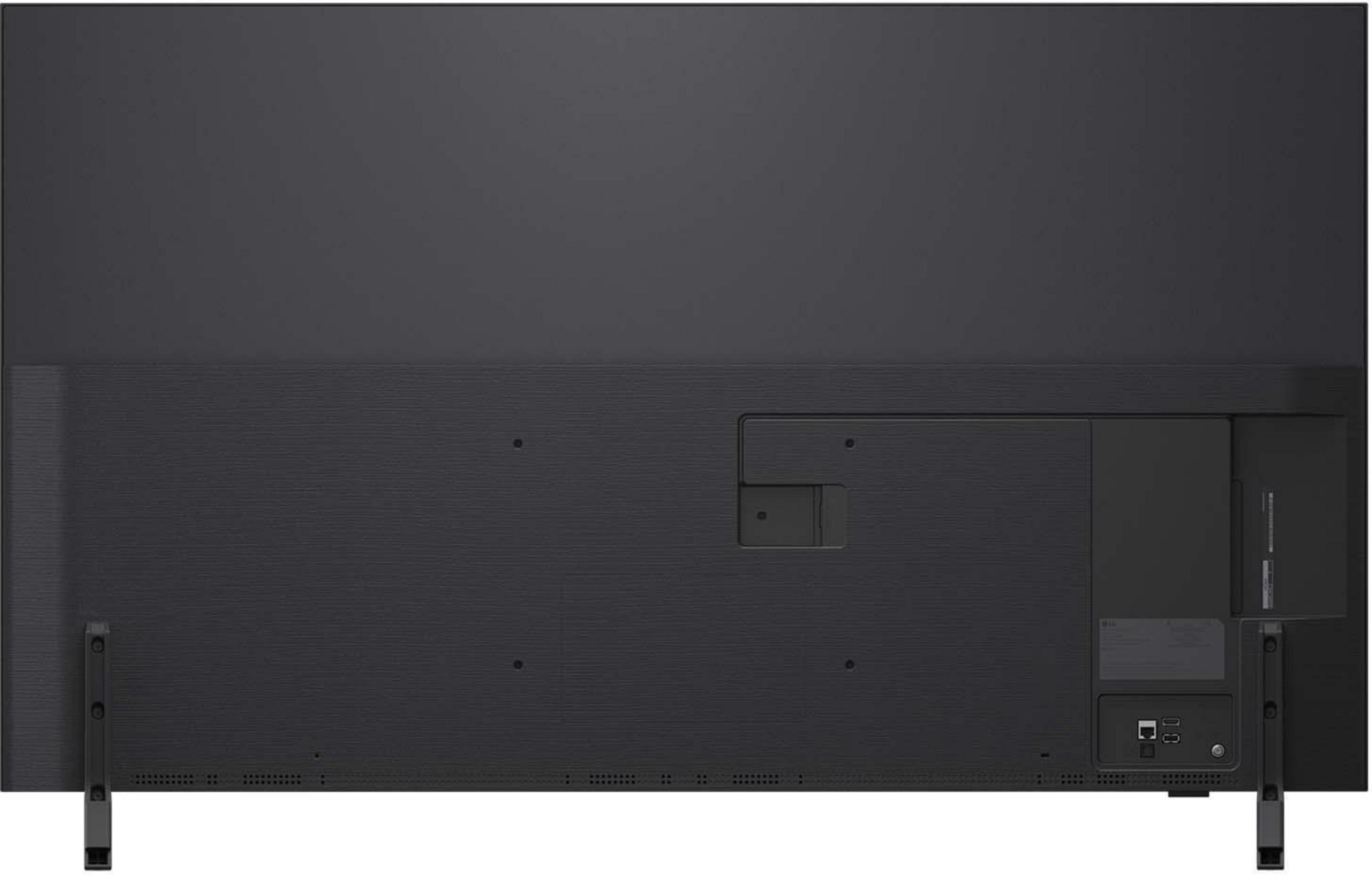 Srebrny laptop, otwarty, na stole. Wyświetla niebiesko-zielony obraz.