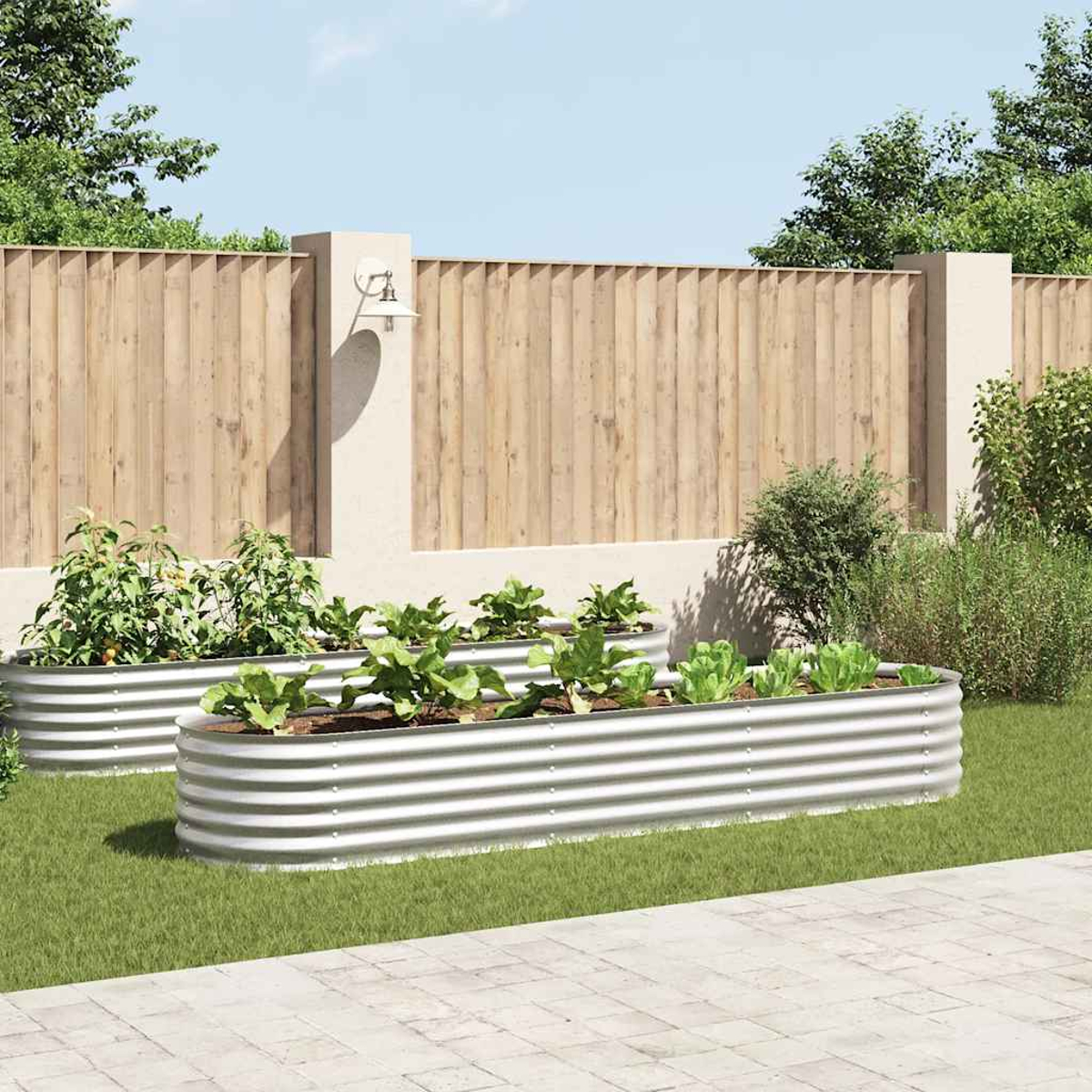 Zwei erhöhte Gartenbeete aus Metall mit Pflanzen vor einem Holzzaun.