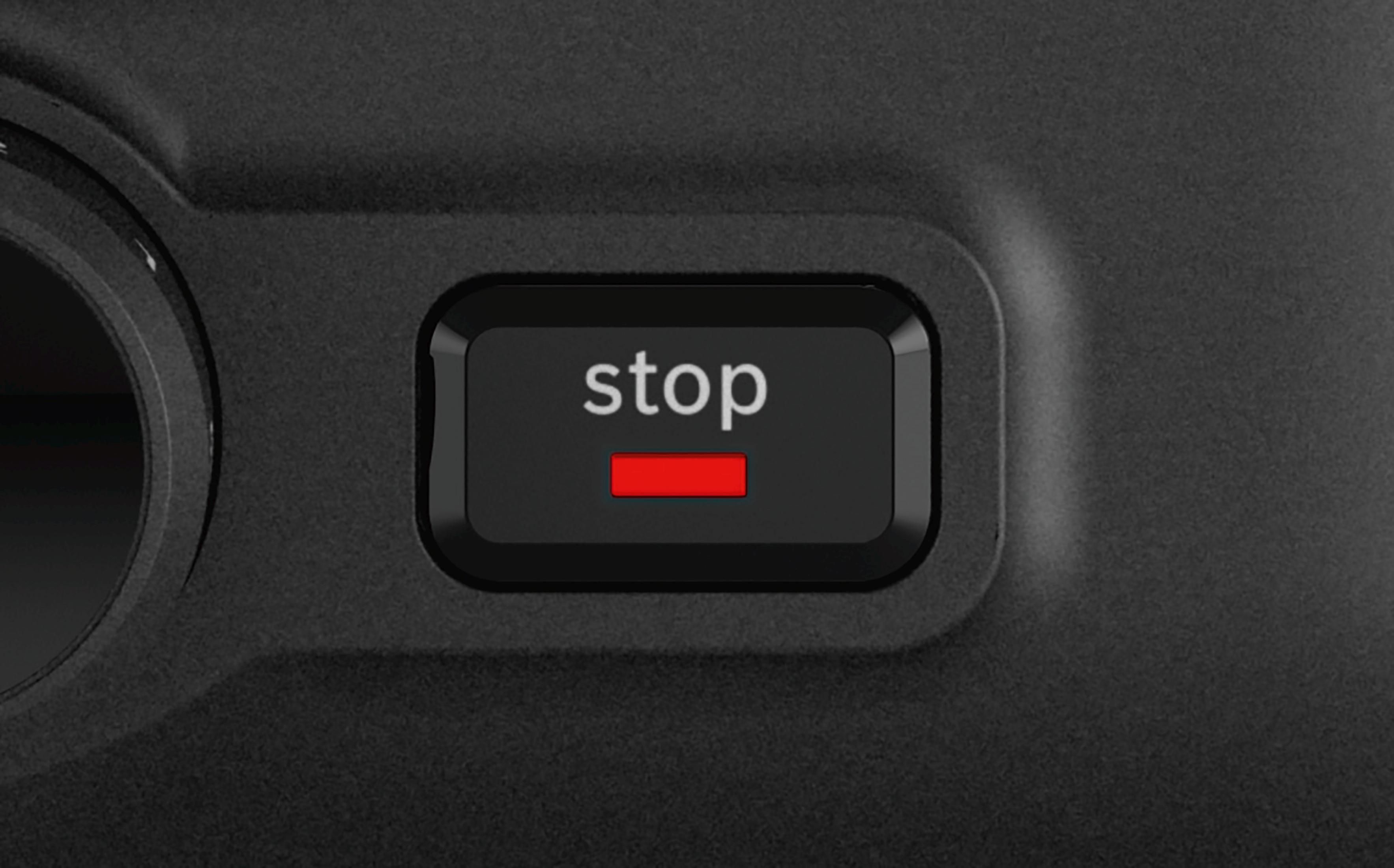 Close-up van een zwarte knop met het woord 'stop' in witte tekst en een rode horizontale lijn.