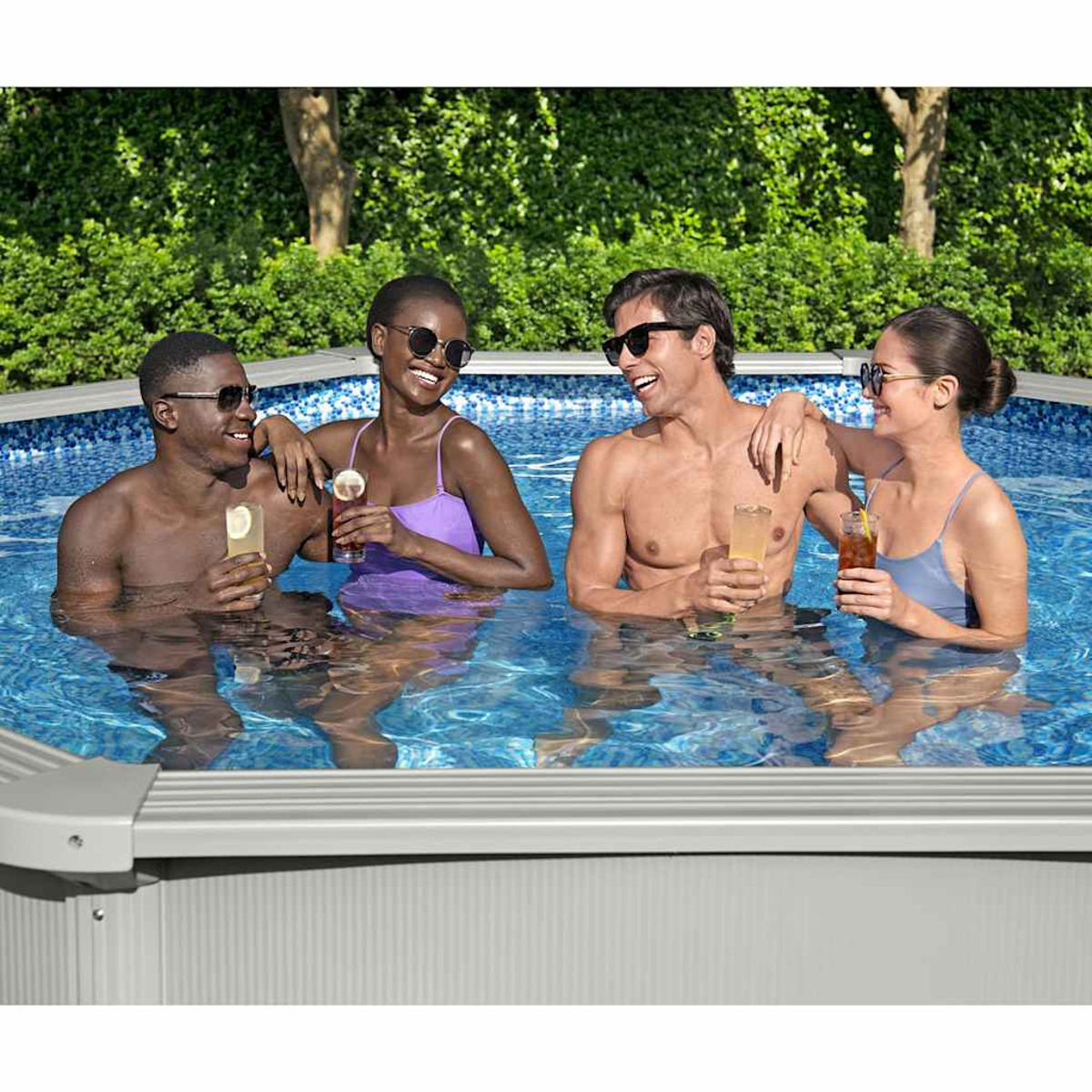 Vier Personen in einem Pool, zwei Männer und zwei Frauen, alle mit Sonnenbrille und Getränken.