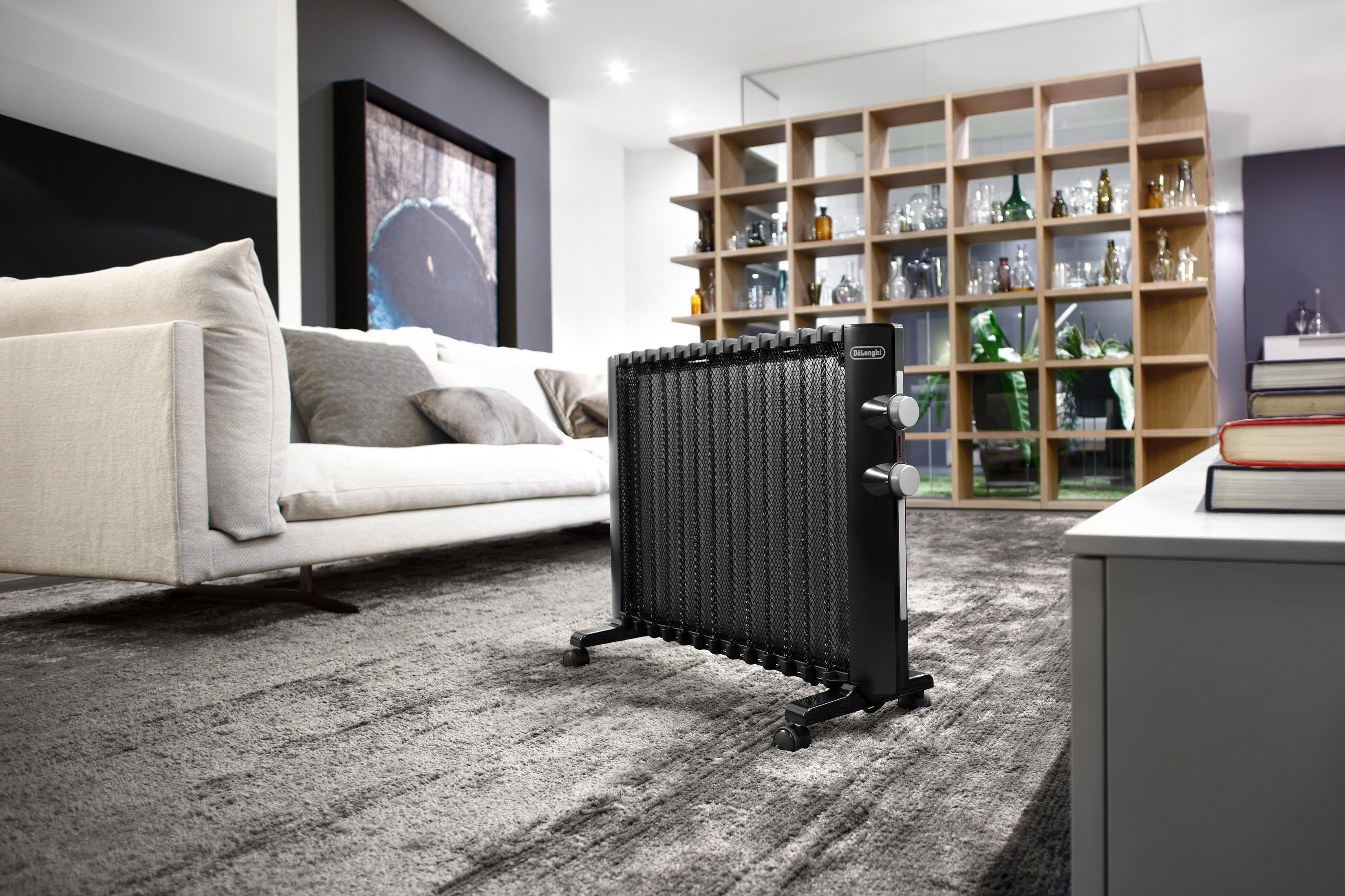 Salon z czarnym kaloryferem i białą sofą. Tło: drewniane półki.