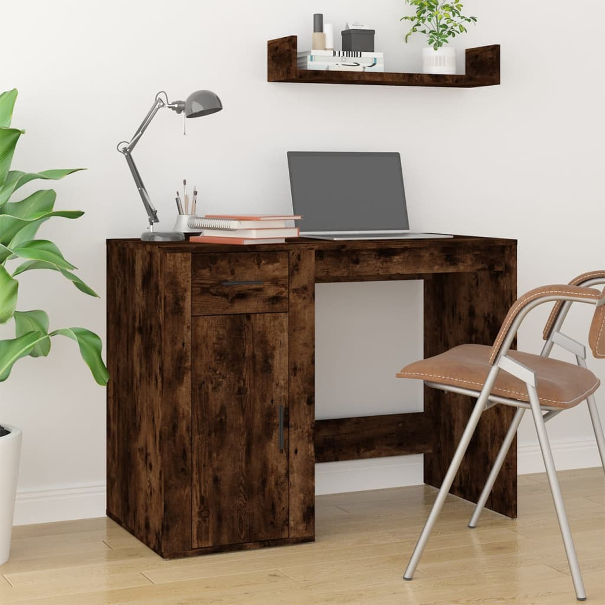 Holzschreibtisch mit Laptop, Lampe, Büchern und Stuhl. Eine Pflanze steht links.