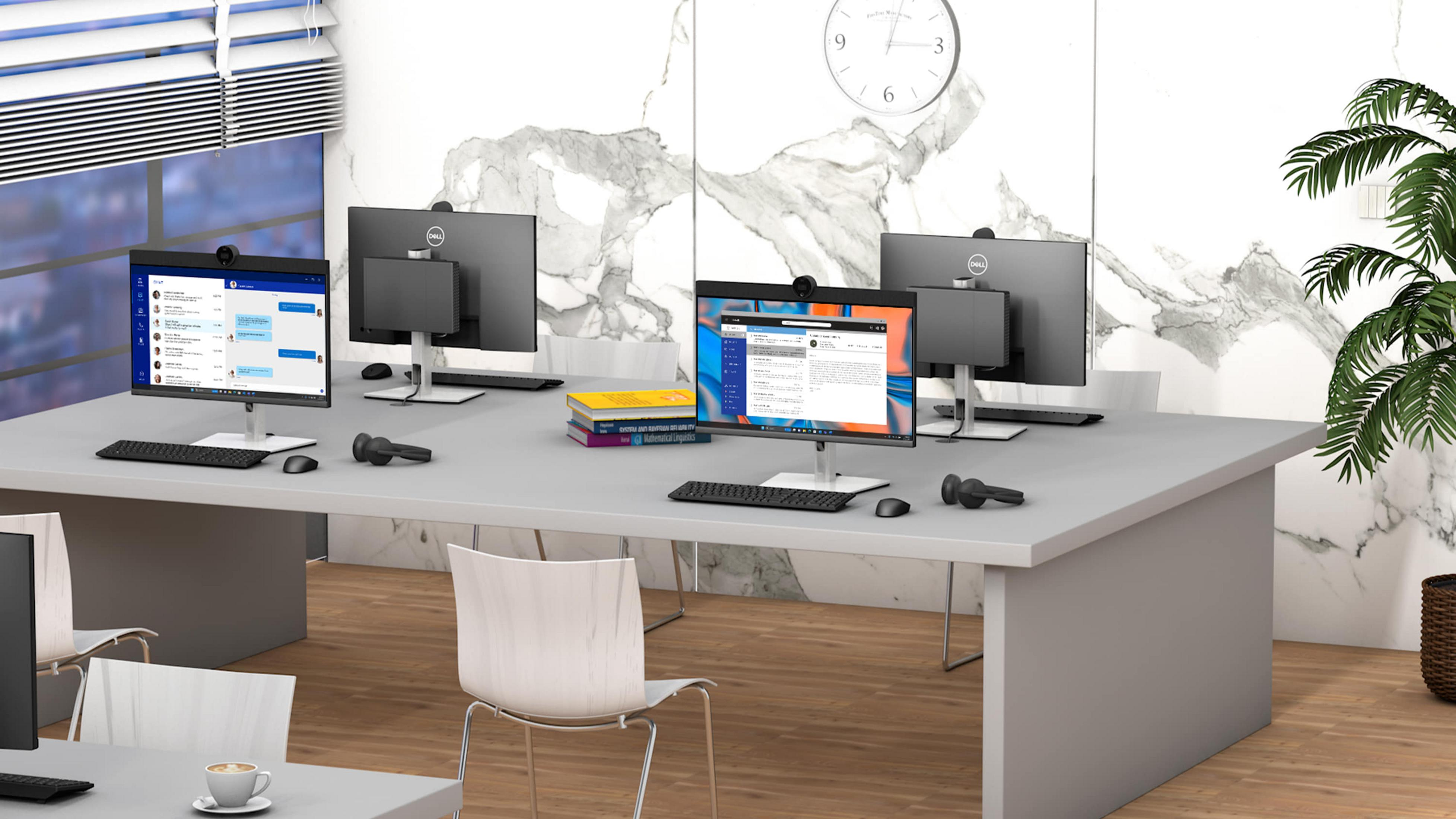 Scena d'ufficio con più monitor di computer e scrivanie.