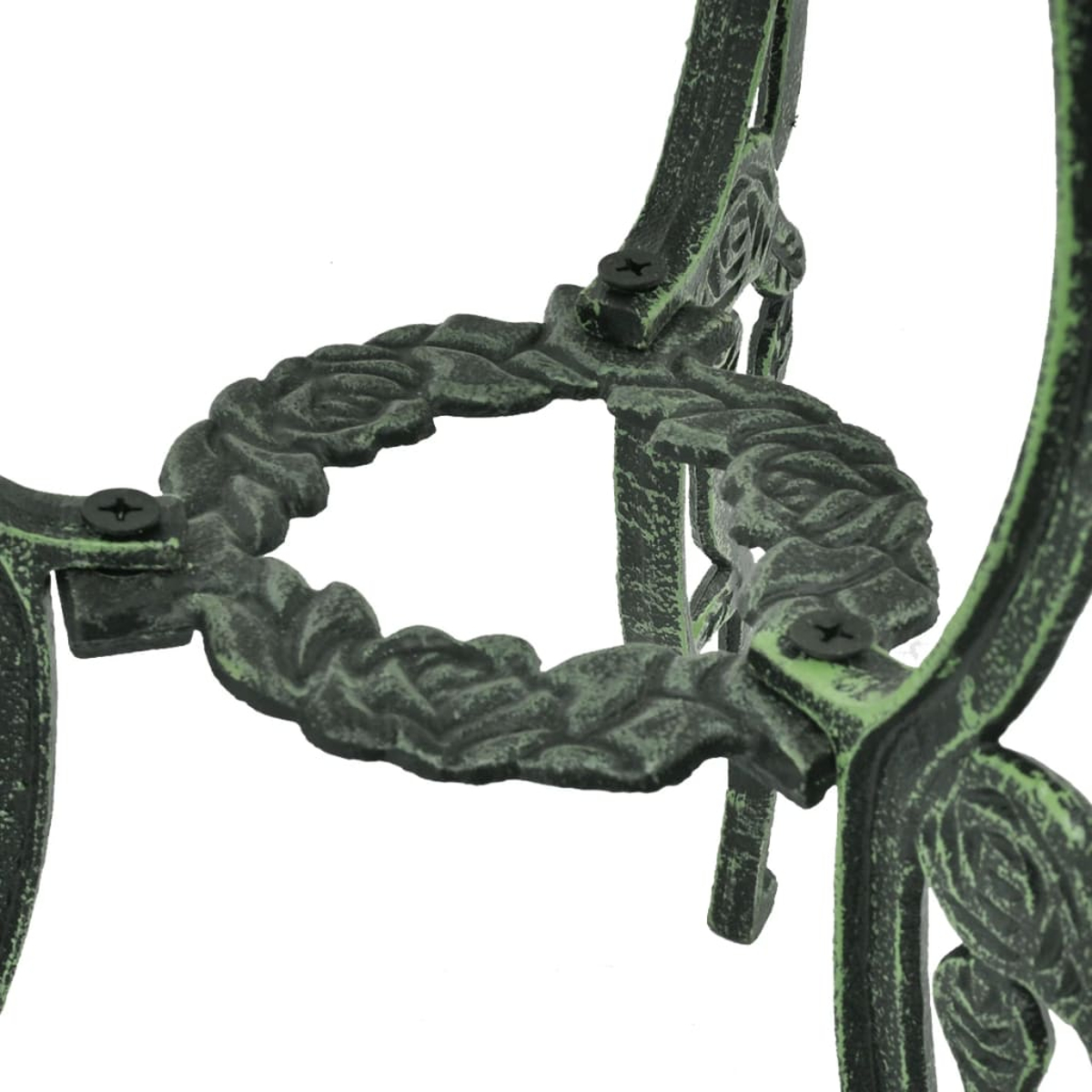 Nahaufnahme eines dekorativen, dunkelgrünen Metalltischbeins mit floralen Details.
