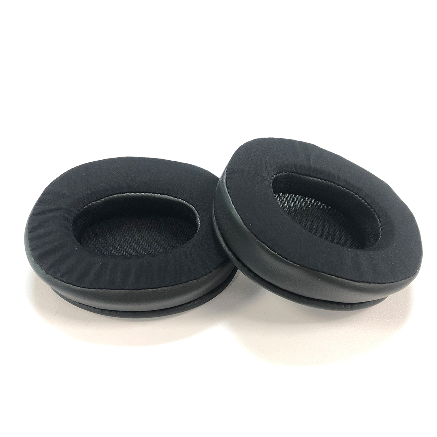 Dwie czarne poduszki nauszne do słuchawek na białym tle.