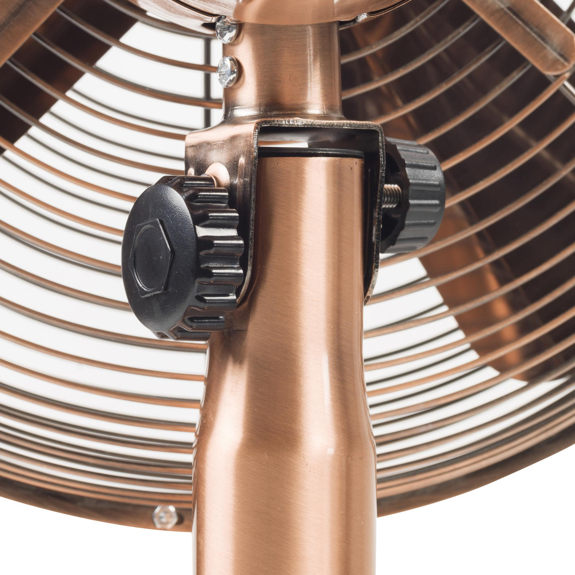 Primo piano dei dettagli metallici di un ventilatore color bronzo: pale, supporto centrale e manopole di regolazione.