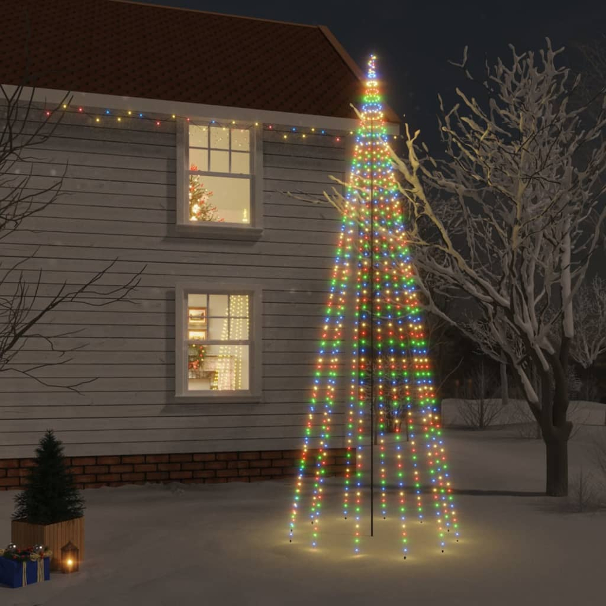 Weihnachtsbaum aus Lichtern vor einem Haus mit Weihnachtsdekorationen.
