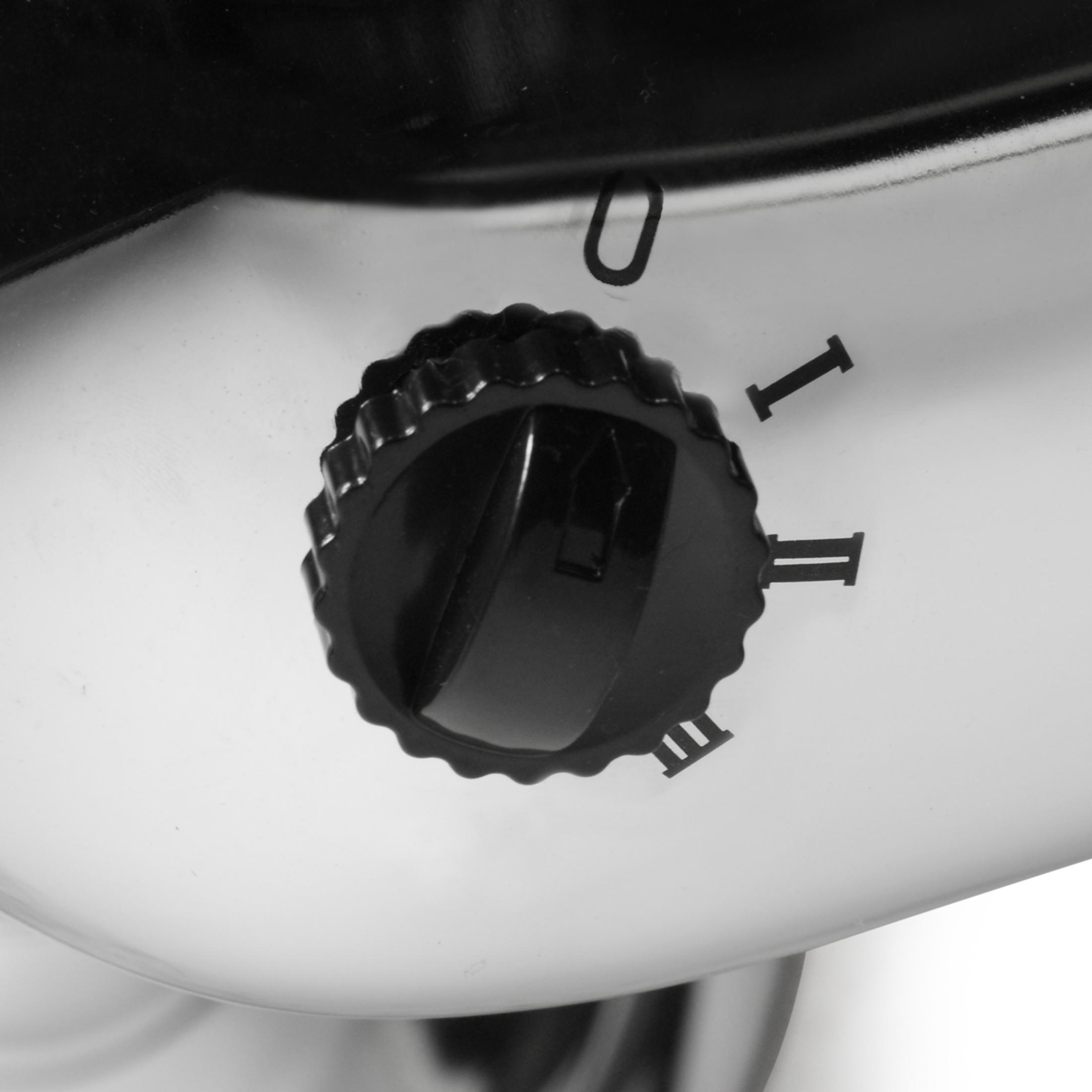 Zbliżenie czarnego pokrętła z oznaczeniami: '0', 'I', 'II' i 'III' na srebrnej powierzchni.